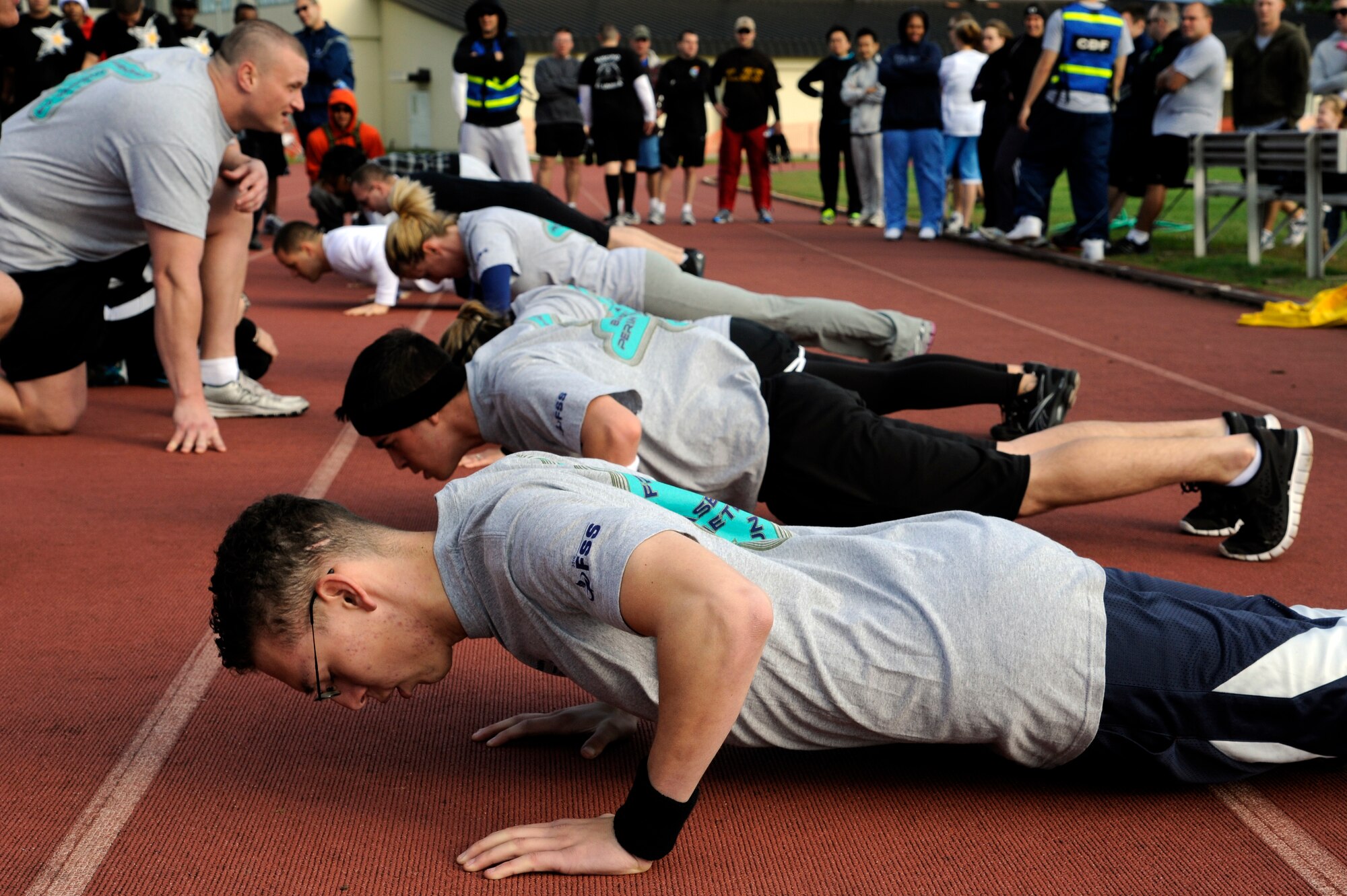 MISAWA AIR BASE, Japan -  Members of the 35th Forces Support Squadron compete in a push-up challenge during the wing sports day here Oct. 7. The 35th Fighter Wing held a sports day to promote physical fitness, teamwork, competition, sportsmanship and esprit de corps. The day was kicked off with a 3-mile run followed by various sporting events to include relay races, basketball, softball, ultimate frisbee, soccer and a readiness competition. Approximately 14 units from the base formed teams to participate in each event. (U.S. Air Force photo/Tech. Sgt. Marie Brown)