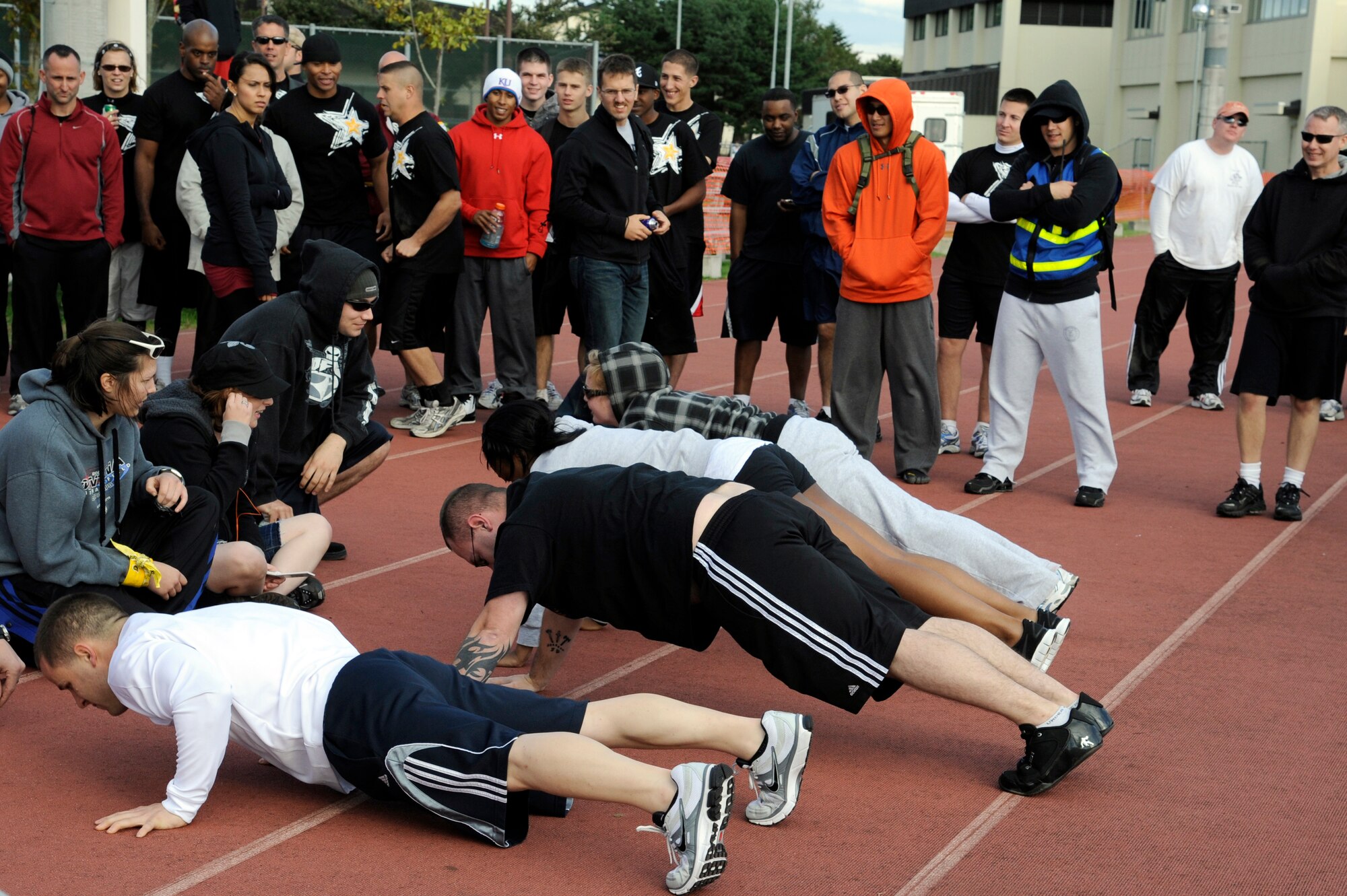MISAWA AIR BASE, Japan - Members of the 35th Aircraft Maintenance Squadron compete in a push-up challenge during the wing sports day here Oct. 7. The 35th Fighter Wing held a sports day to promote physical fitness, teamwork, competition, sportsmanship and esprit de corps. The day was kicked off with a 3-mile run followed by various sporting events to include relay races, basketball, softball, ultimate frisbee, soccer and a readiness competition. Approximately 14 units from the base formed teams to participate in each event. (U.S. Air Force photo/Tech. Sgt. Marie Brown)
