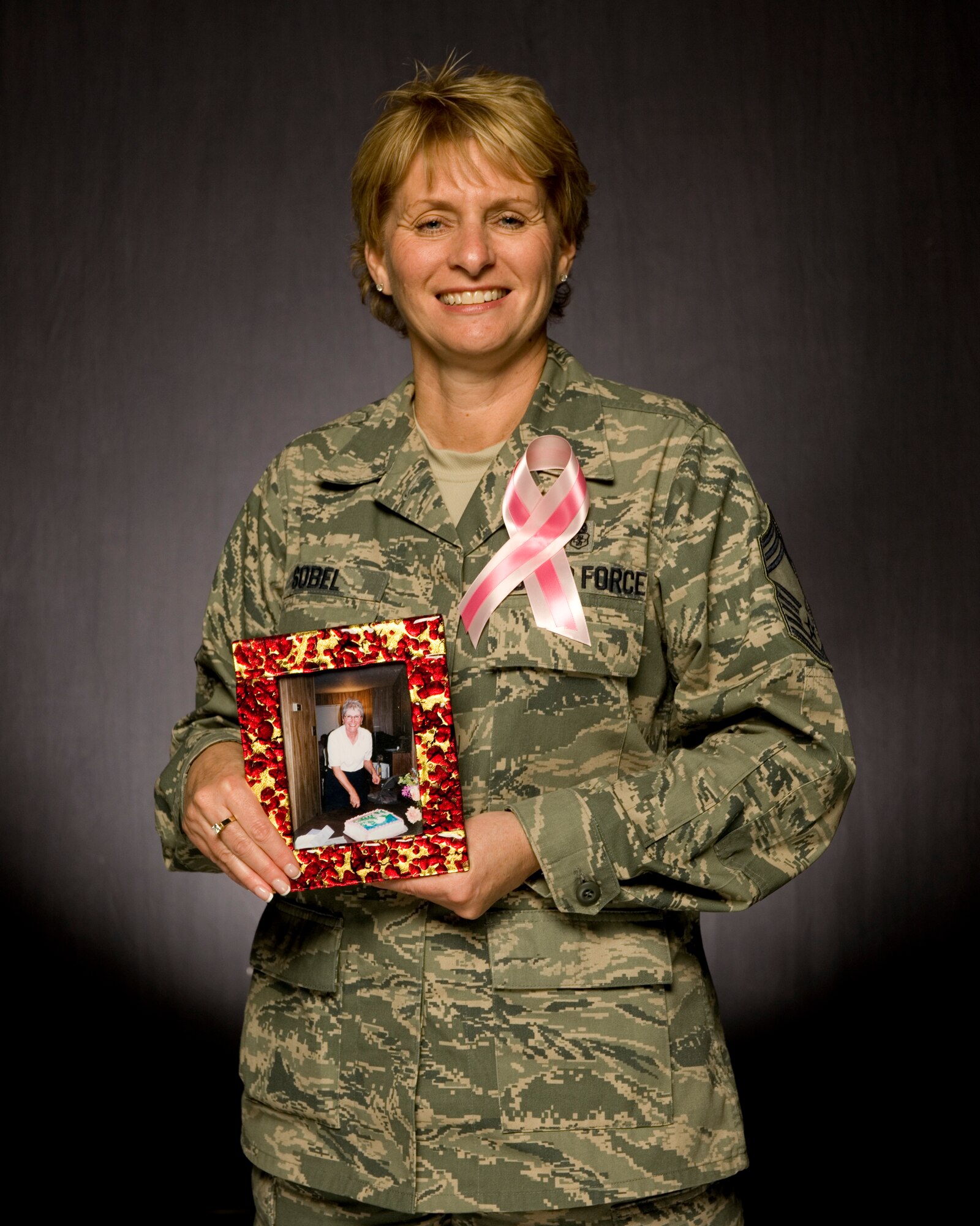 VANDENBERG AIR FORCE BASE, Calif.- Chief Master Sgt. Michelle Sobel, 30th Medical Group superintendant and a breast cancer survivor, poses with a photograph of her mother here Wednesday, Oct. 12, 2011. Sobel's mother lost her battle with breast cancer in 2007. (U.S. Air Force/Staff Sgt. Levi Riendeau)