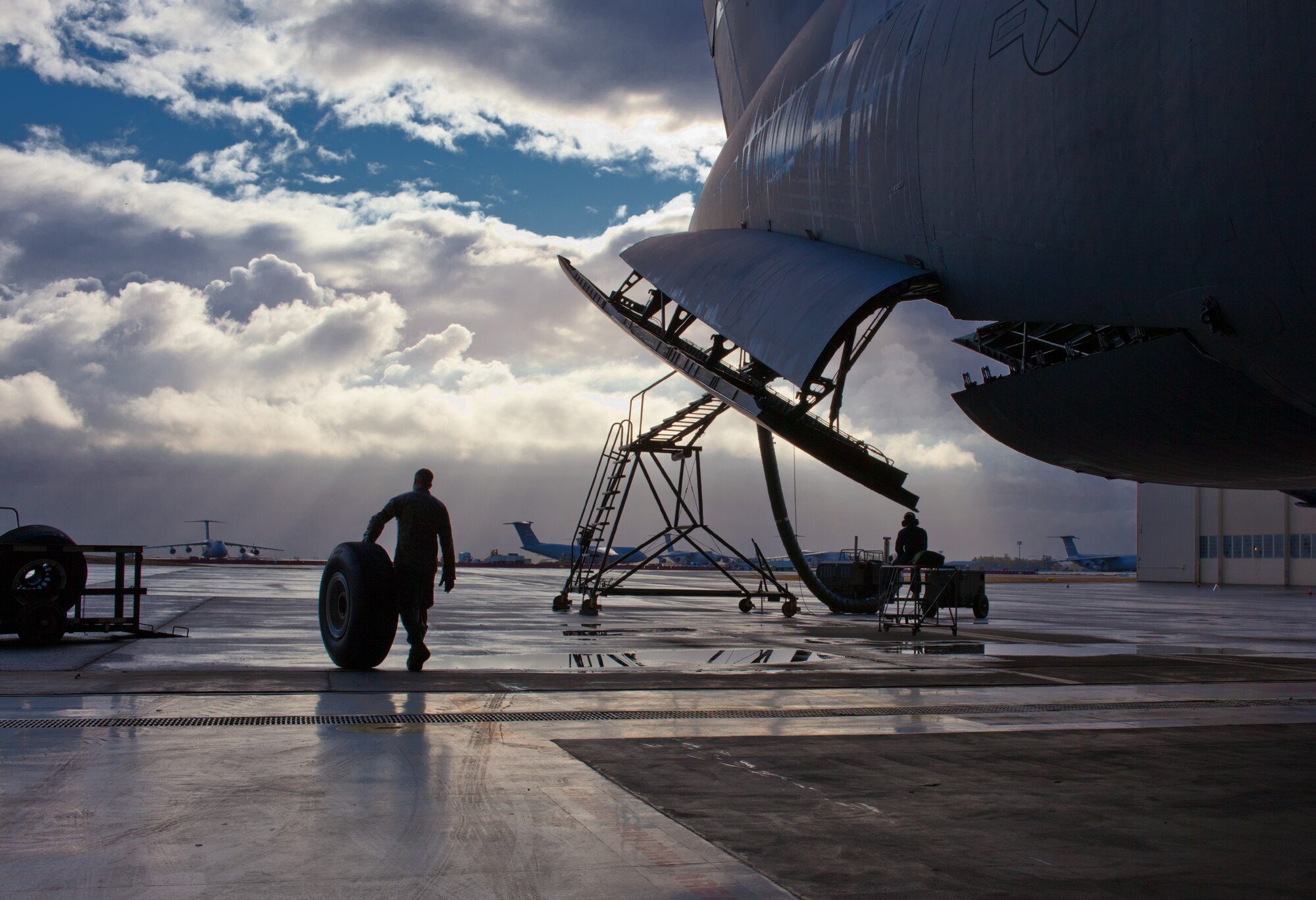 Senior Airman Justin Evans, crew chief with the 60th Aircraft Maintenance Squadron, rolls a used C-5 Galaxy tire-and-wheel assembly to collection point after its removal from and aircraft Oct. 6, 2011 at Travis Air Force Base, Calif.  The installation's fleet will soon be part of a worldwide surge of C-5 aircraft. The surge, slated to take place between 17-21 Oct., will bring together 18 active-duty and 23 Air National Guard and Air Force Reserve Command crews and 41 total-force C-5 Galaxy aircraft to move cargo and passengers in support of combatant commanders across the globe.  (U.S. Air Force photo / Lt. Col. Robert Couse-Baker)