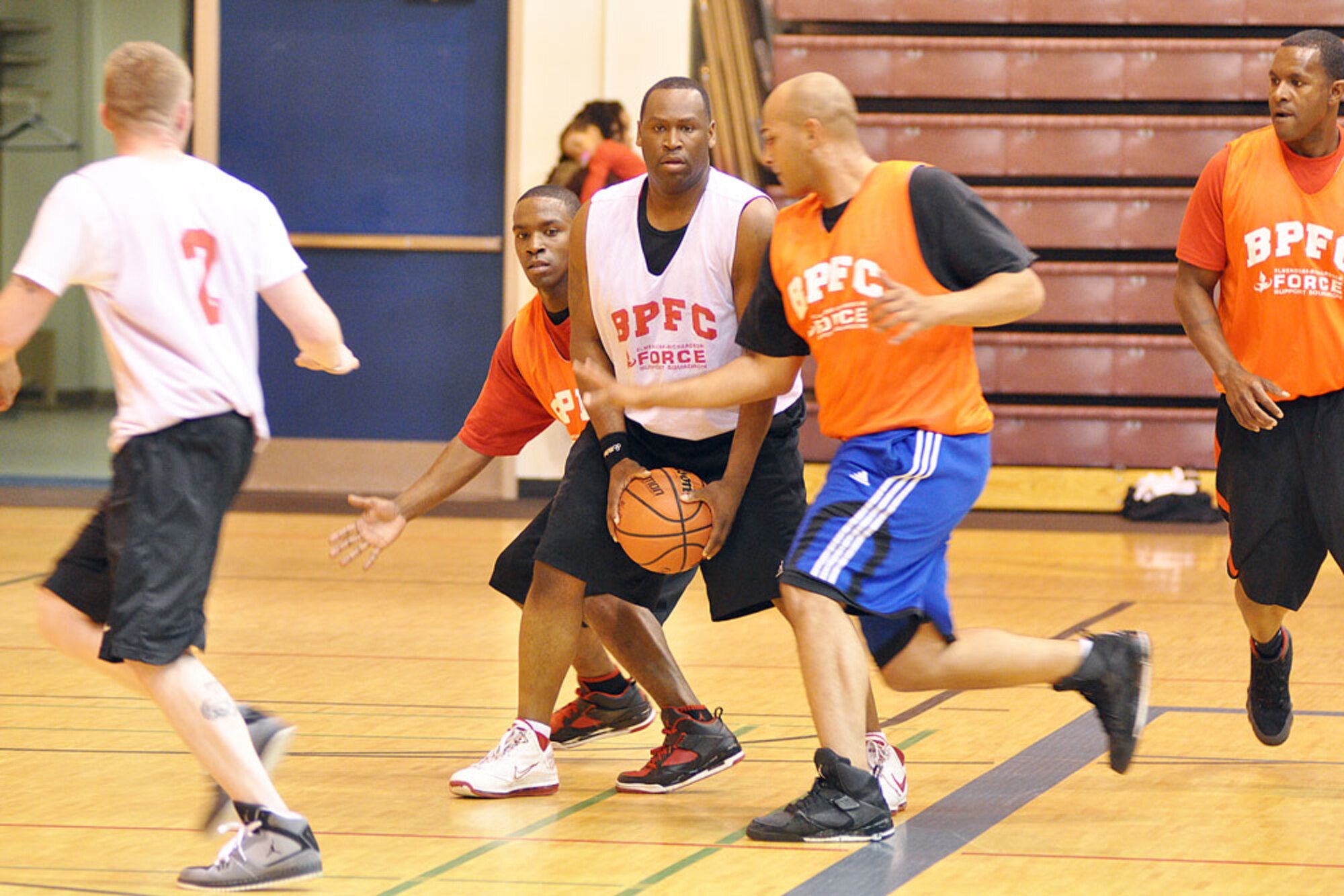 Carmartrus Porter (white jersey) tries to protect the basketball from the HHB, 2-377th PFAR defense in the opening game of the Joint Base Elmendorf-Richardson pre-season basketball tournament at Buckner Physical Fitness Center Monday night. Porter played for Headquarters and Headquarters Detchament, 59th Signal Battalion. (U.S. Air Force photo/John Pennell)