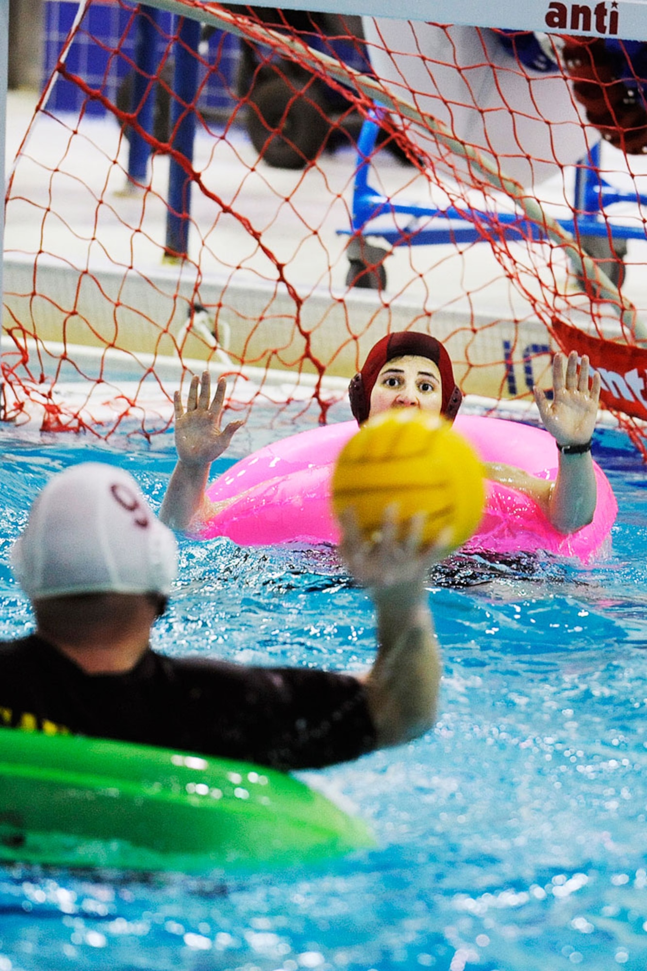 Alaska National Guard player Jarrett Carson takes a shot on goal as Health and Wellness Center goalie Allison Anderson prepares to try to block the shot in the opening match of the Joint Base Elmendorf-Richardson inner tube water polo tournament Oct. 5. The AKNG team beat HAWC  9-5. (U.S. Air Force photo/John Pennell)