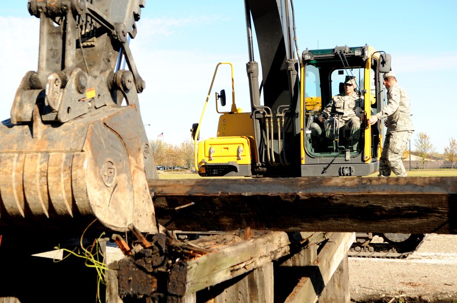 Brig. Gen. Timothy Green, Director of Installations and Mission Support for the U.S. Air Force Air Mobility Command, demolishes an old loading dock with the help of Airman 1st Class Cody Salisbury, 319th Civil Engineering Squadron, on Grand Forks Air Force Base, N.D., on Oct. 11. General Green was at Grand Forks for a site visit and to participate in the U.S. Air Force Expeditionary Center Commander’s Conference. (U.S. Air Force photo by Senior Airman Amanda N. Stencil)
