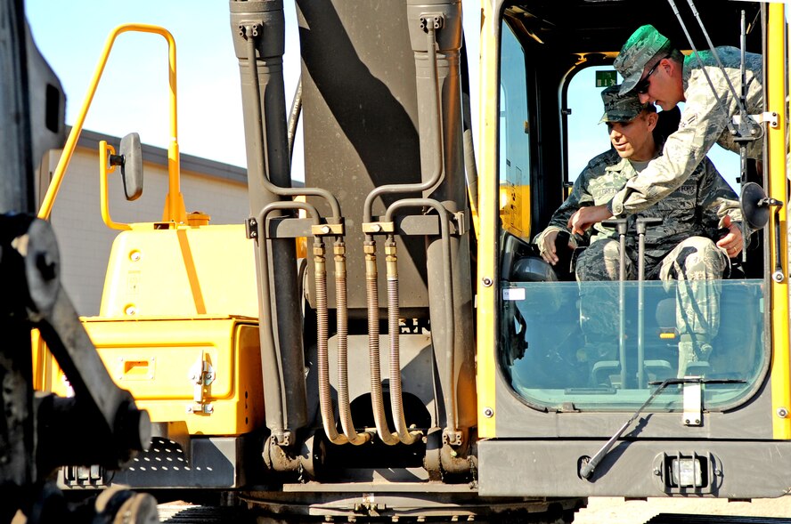 Airman 1st Class Cody Salisbury, 319th Civil Engineering Squadron, shows Brig. Gen. Timothy Green, Director of Installations and Mission Support for the U.S. Air Force Air Mobility Command, how to operate an excavator during his tour of Grand Forks Air Force Base, N.D., on Oct. 11. General Green was at Grand Forks for a site visit and to participate in the U.S. Air Force Expeditionary Center Commander’s Conference. (U.S. Air Force photo by Senior Airman Amanda N. Stencil)