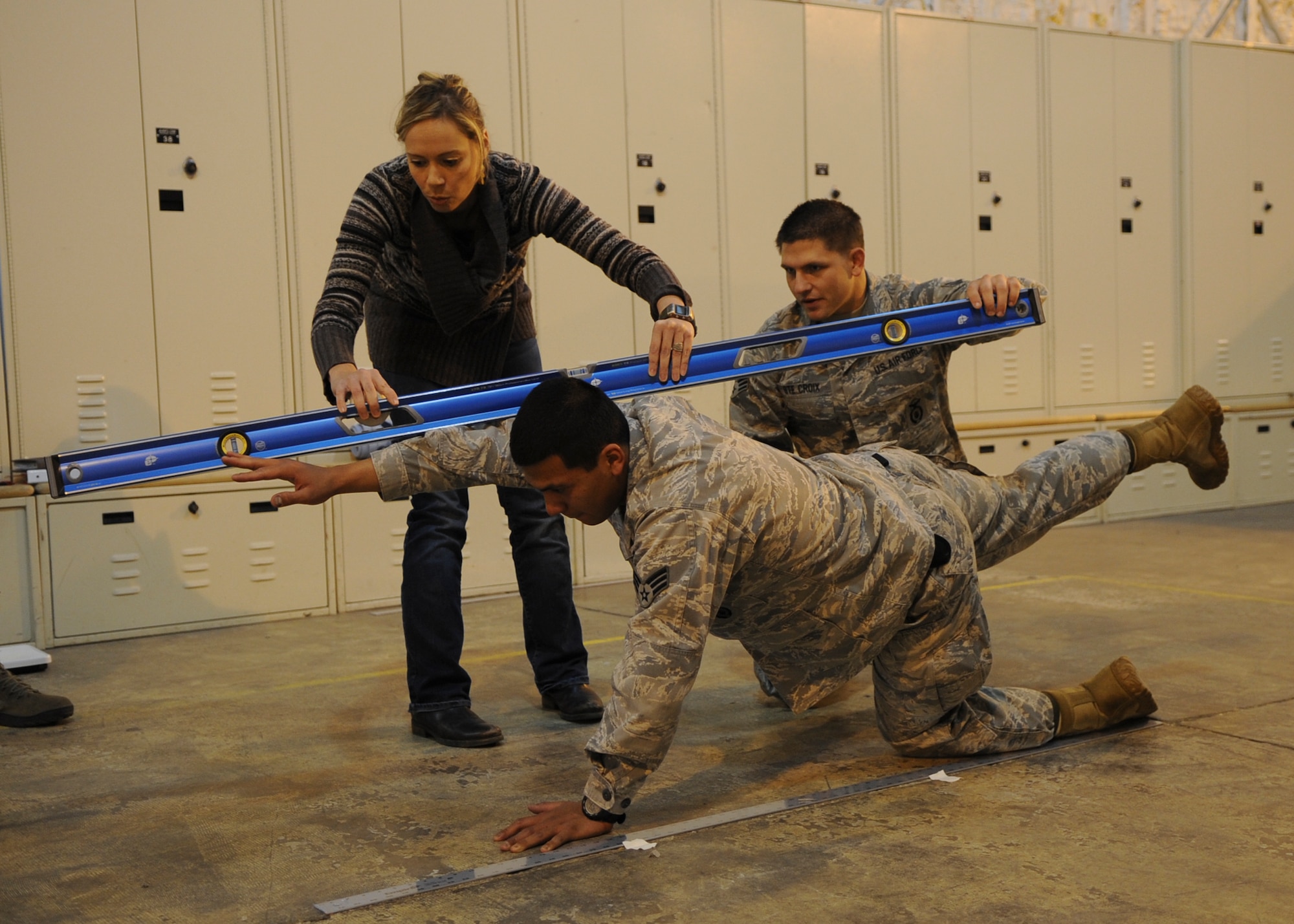 MINOT AIR FORCE BASE, N.D. -- Ty Colvin (left), wife of Capt. Neil Colvin, 91st Security Forces Group Tactical Response Force operations officer, and Senior Airman Richard Ste Croix, 91st SFS TRF marksman, works with TRF volunteers in a doctoral physical assessment here, Sept. 9. TRF volunteers performed exercises with and without full battle gear to demonstrate how the equipment makes movement difficult. These volunteers are currently participating in a doctoral study which assesses any physical weaknesses or injuries they may have. The assessment can potentially reduce injuries in the Air Force. (U.S. Air Force photo/Senior Airman Ashley N. Avecilla)