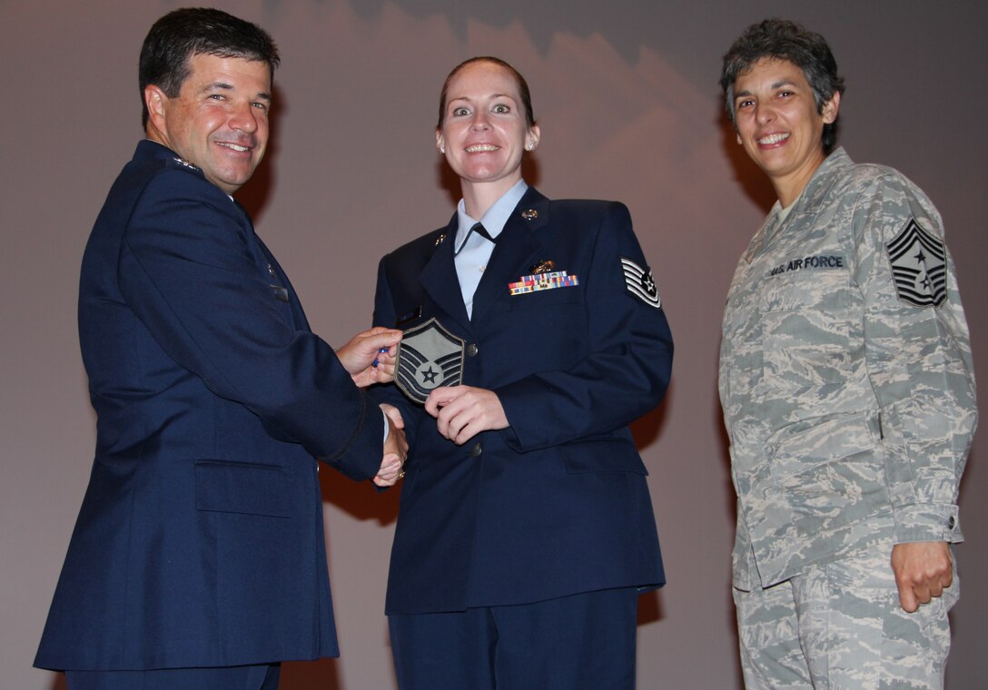 Col. William Edwards, 932nd Airlift Wing commander, surprised new Master Sgt. Ashley Shaffer with her stripes at commander's call.  Also on stage was 932nd AW Command Chief  Sandra Santos.  The Program for Enhanced Promotion (PEP) promotes well-deserving Air Force Reserve Command personnel.  Only category A reservists are eligible for PEP.  (U.S. Air Force photo/Tech. Sgt. Dan Oliver)   