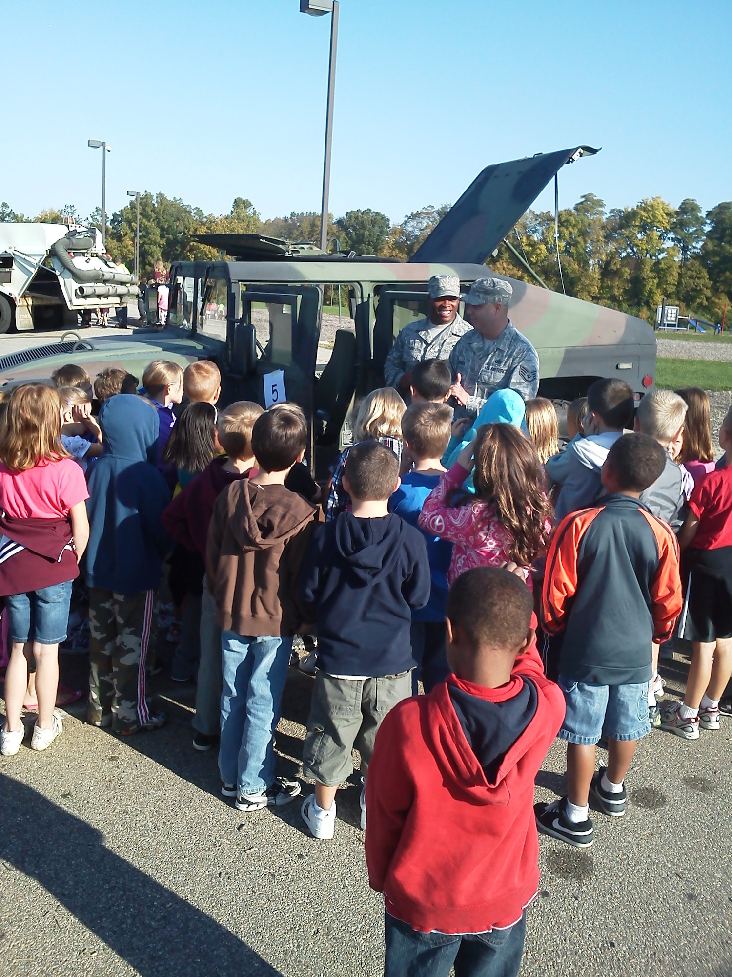 Staff Sgt. Brian Parrish, 88th Security Forces Squadron, and Staff Sgt. Gary Rand, 88th Air Base Wing Plans and Programs, greet students at Bowman Elementary School in Lebanon, Ohio on Oct. 7 to participate in "Vehicle Day."  The Airmen were peppered with questions ranging from "why do you wear a uniform," to "have you ever been shot?"  (US Air Force photo by Kraig Bradford)     
