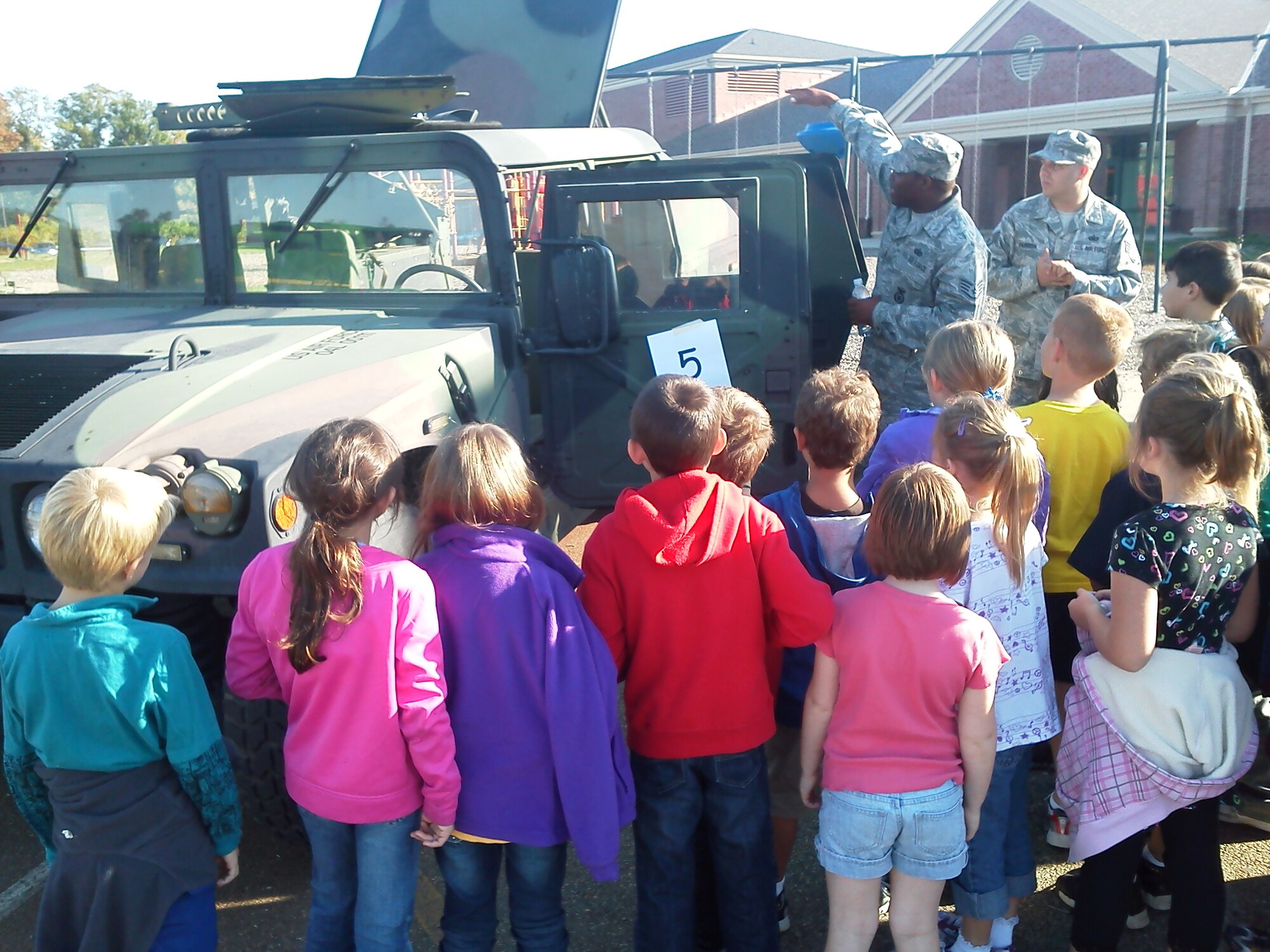 Staff Sgt. Gary Rand, 88th Air Base Wing Plans and Programs, points out features of the High Mobility Multipurpose Wheeled Vehicle (HMMWV), better known as the Humvee, to students at Bowman Elementary School in Lebanon, Ohio.  (US Air Force photo by Kraig Bradford)       