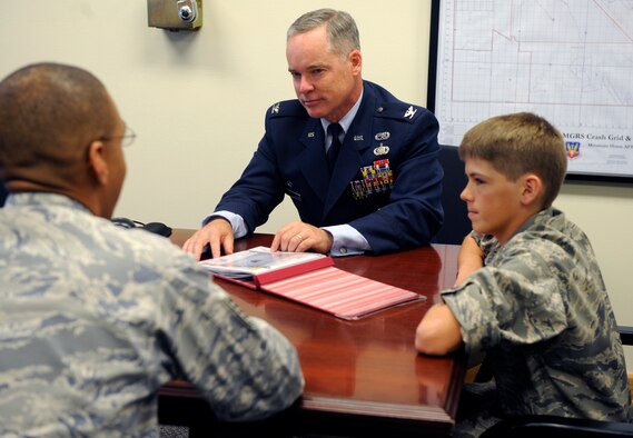 U.S. Air Force Col. James McClellan, 366th Maintenance Group commander, meets with Carson McIe at Mountain Home Air Force Base, Idaho, Oct. 5. Carson was flown here by members of the 389th Aircraft Maintenance Unit and received a base tour as a thank you for raising more than $1,000 in care packages during the unit’s deployment. Carson and his family are residents of Galion, Ohio, and have no military affiliation. (U.S. Air Force photo by Senior Airman Angelina Drake/Released) 
