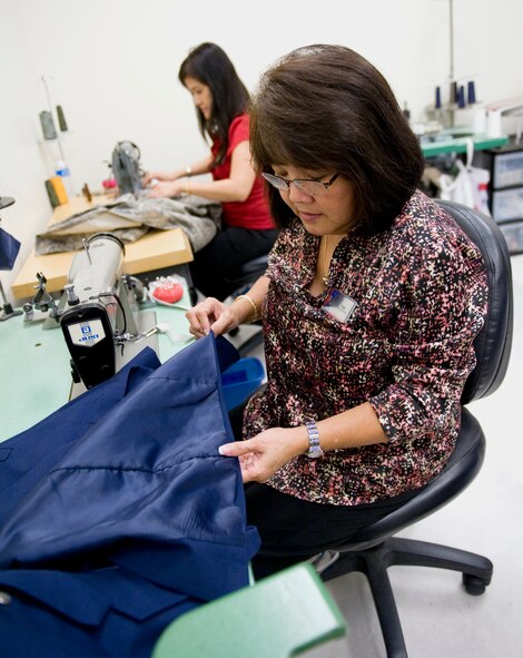 Tam Harper, front, and Jantip Sangprom alter military uniforms at the Stripes alterations shop on Barksdale Air Force Base, La., Oct. 12. Stripes, located inside the Base Exchange, gives U.S. service members convenient alterations services on base. (U.S. Air Force photo/Airman 1st Class Benjamin Gonsier)(RELEASED)