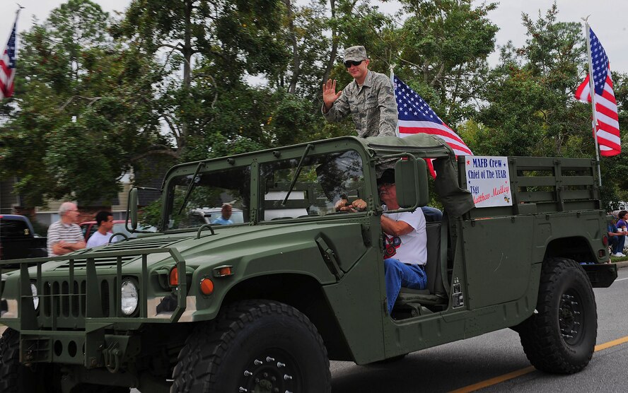U.S. Air Force Tech. Sgt. Matthew Medley, 723rd Aircraft Maintenance Squadron aerospace maintenance craftsman, rides on top of a Humvee during the Honeybee Festival parade in Hahira, Ga., Oct. 8 2011. Medley was recognized for being selected Air Combat Command crew chief of the year. (U.S. Air Force photo by Staff Sgt. Stephanie Mancha/Released)
