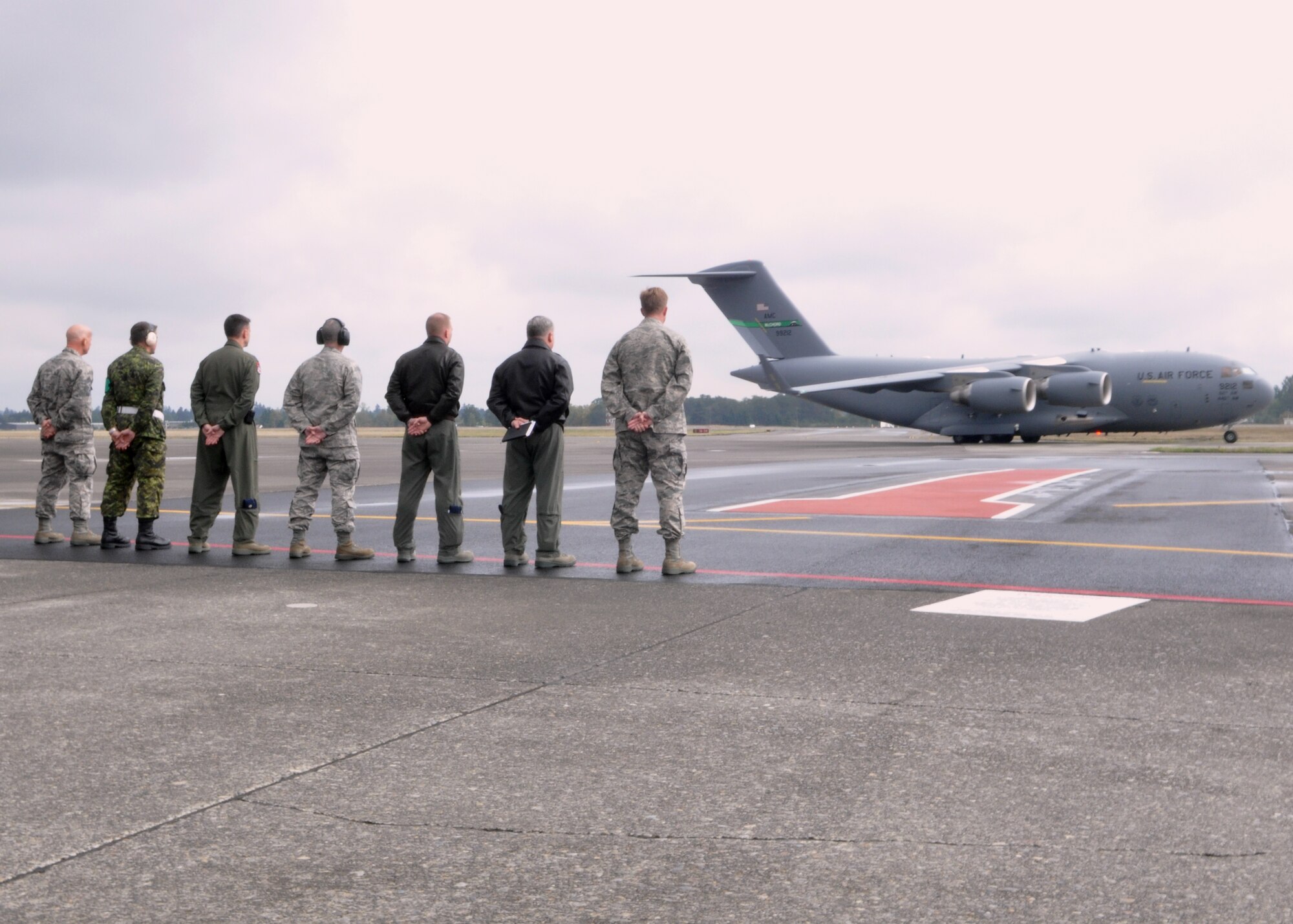 62nd Airlift Wing leadership stands at ease while McChord Field’s newest C-17 Globemaster III taxis down the runway Oct. 6, 2011, at Joint Base Lewis-McChord, Wash. The C-17 is the newest, most flexible cargo aircraft to enter the airlift force. 
 (U.S. Air Force photo/Airman 1st Class Leah Young)

