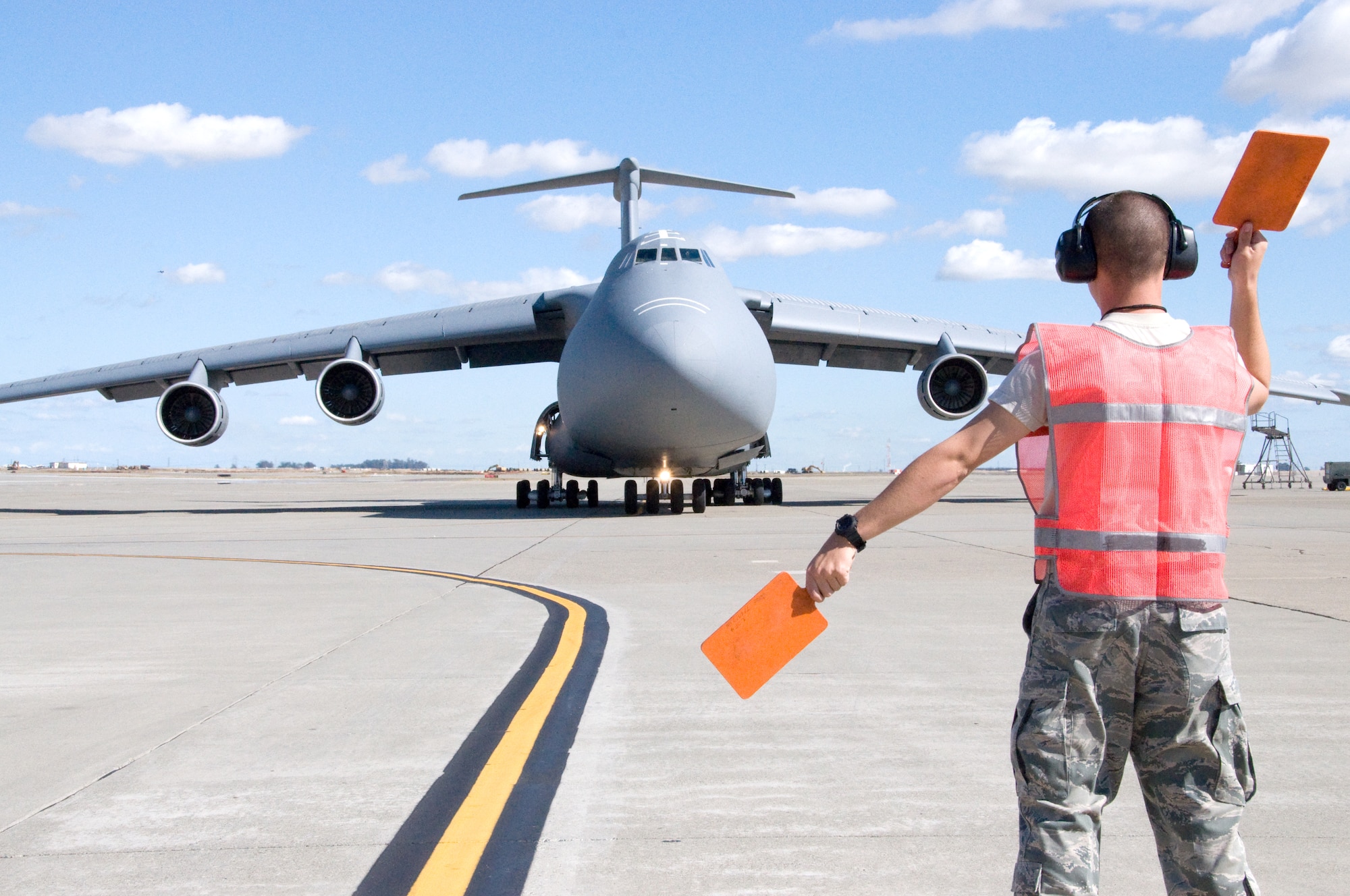 Senior Airman Ryan Arostegui, 349th Aircraft Maintenance Squadron crew chief, marshalls a C-5 Galaxy Tuesday during an acceptance inspection flight at Travis. The 1970 Galaxy is one of the last to recieve avionics upgrades. (U.S. Air Force photo/Staff Sgt. Timothy Boyer)