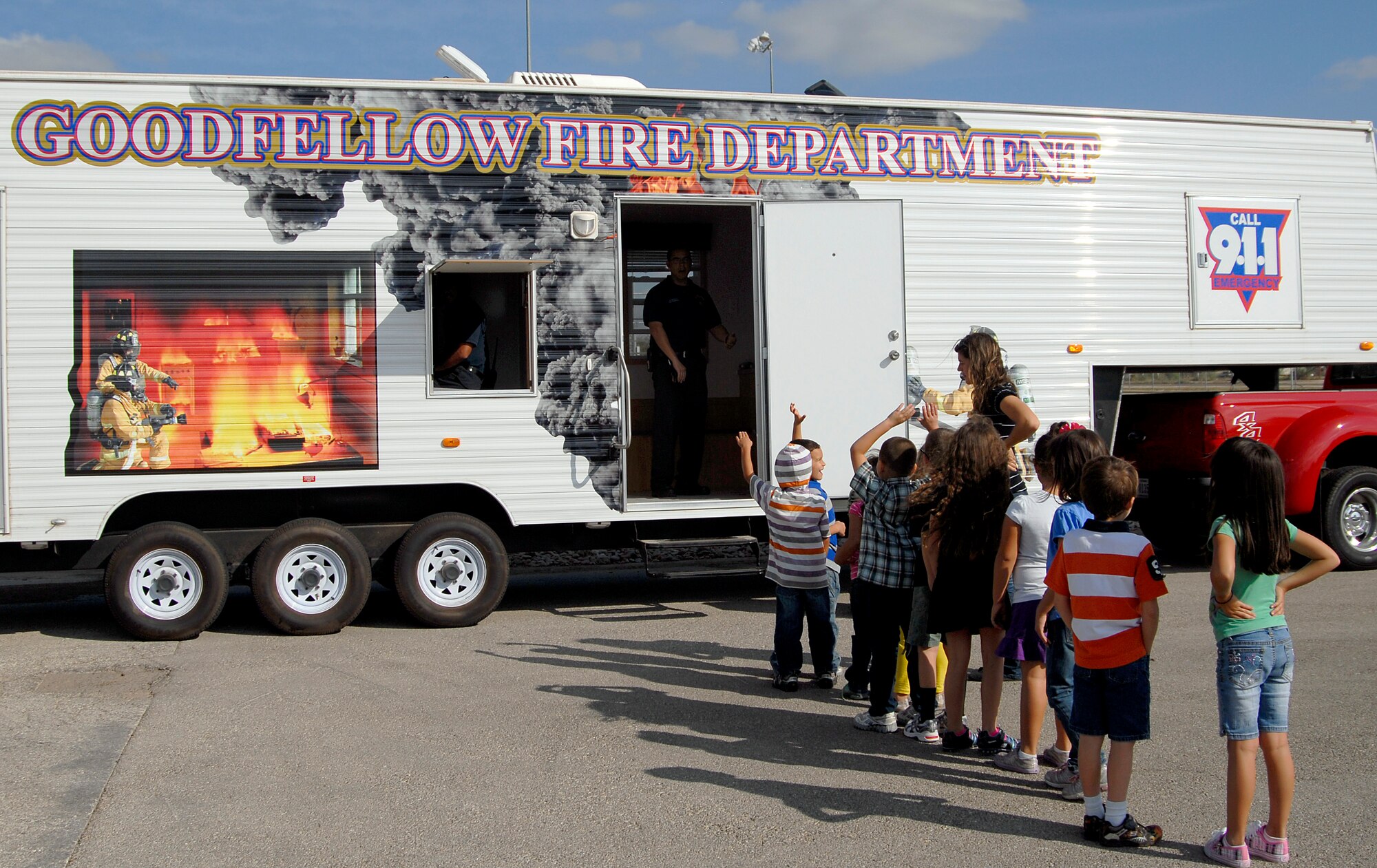 GOODFELLOW AIR FORCE BASE, Texas – Children line up to enter a fire safety house outside the School Age Program Center here Oct. 11. Members from Goodfellow’s Fire Department visited the center as part of the 89th National Fire Prevention Week. The children learned about fire safety using the fire safety house, visited with Sparky the firedog, explored a fire truck and became familiar with firefighters during the visit. (U.S. Air Force photo /Senior Airman Heather L. Rodgers)