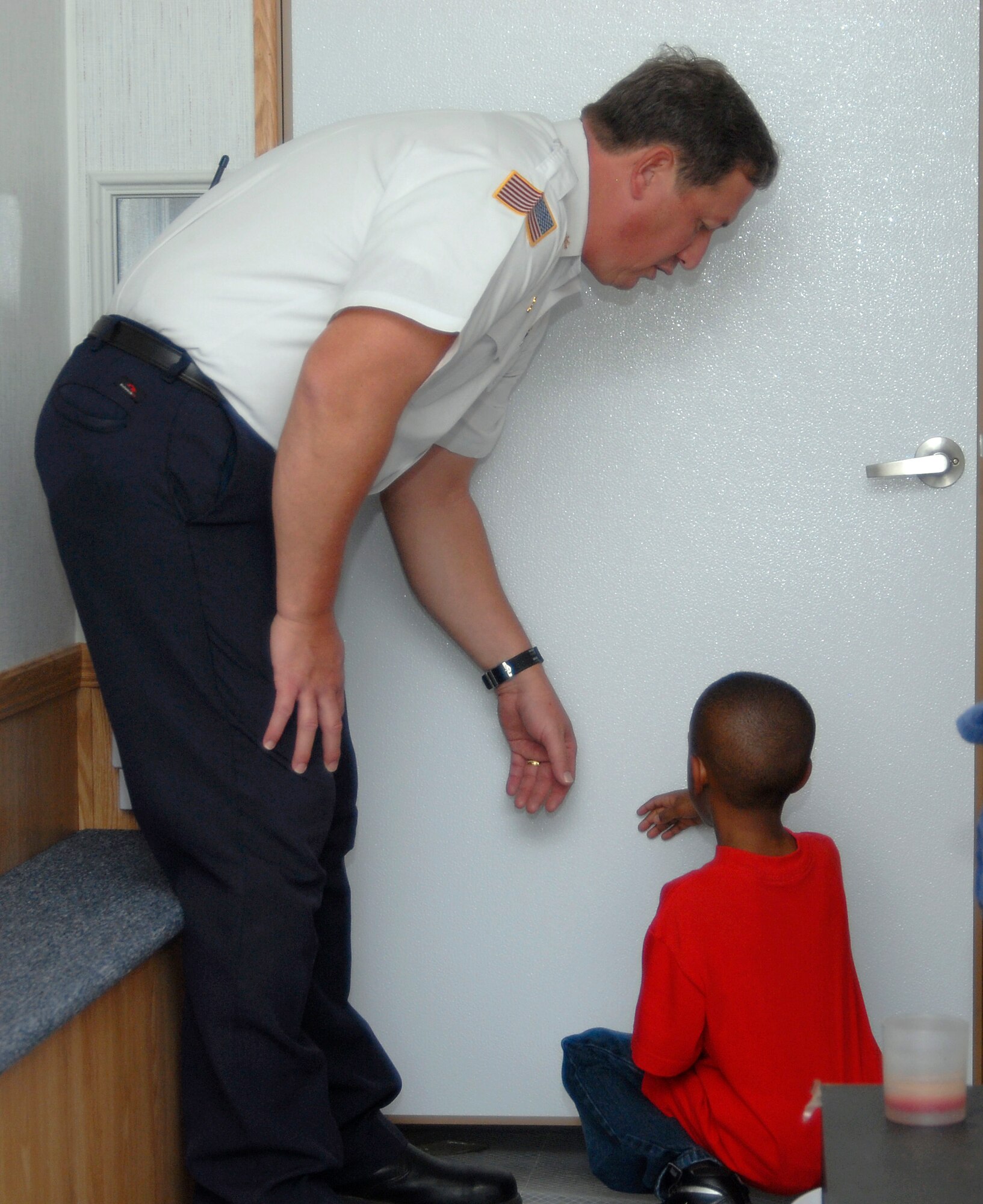 GOODFELLOW AIR FORCE BASE, Texas –Glenn Haffner, Goodfellow Fire Department, demonstrates how to feel for heat when opening doors if smoke is present during a visit to the School Age Program Center here Oct. 11. Members from Goodfellow’s Fire Department visited the center as part of the 89th National Fire Prevention Week. The children learned about fire safety using the fire safety house, visited with Sparky the firedog, explored a fire truck and became familiar with firefighters during the visit. (U.S. Air Force photo /Senior Airman Heather L. Rodgers)