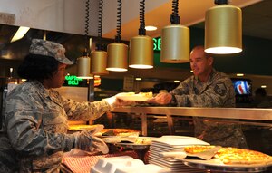 1st Lt. Keturah Johnson, 633rd Force Support Squadron food service officer, serves Master Sgt. Robert West, 633rd Logistic Readiness Squadron quality assurance liaison, pizza during lunch at the Crossbow Dining Facility at Langley Air Force Base, Va., Oct. 6, 2011. The 633rd FSS is competing for the John L. Hennessy Trophy, which is awarded to Air Force installations for having the best food-service program in the Air Force.  (U.S. Air Force photo by Airman 1st Camilla Griffin/Released)