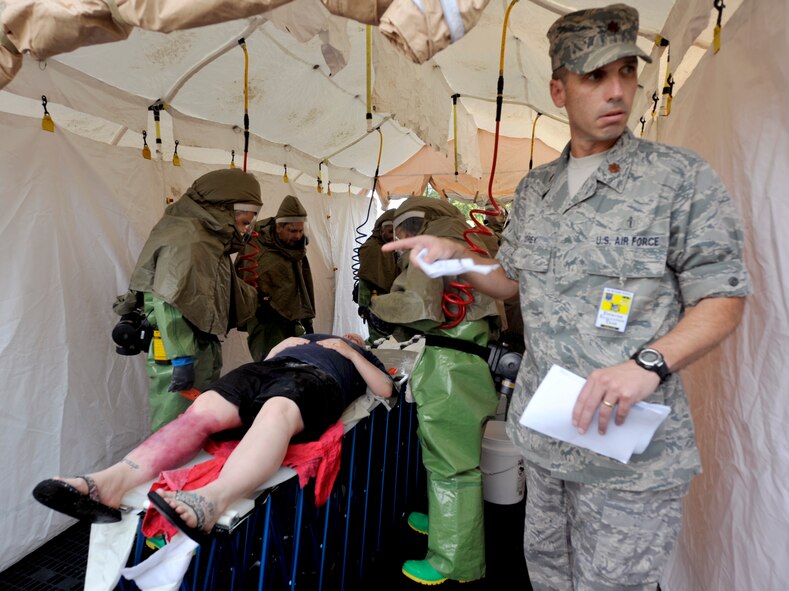 An Exercise Evaluation Team member watches as Airmen from the 2nd Medical Group decontaminate a simulated victim as part of a major accident response exercise on Barksdale Air Force Base, La., Aug. 25. The MARE was used to provide feedback to wing leadership about emergency management capabilities. (U.S. Air Force photo/Senior Airman Chad Warren)(RELEASED)