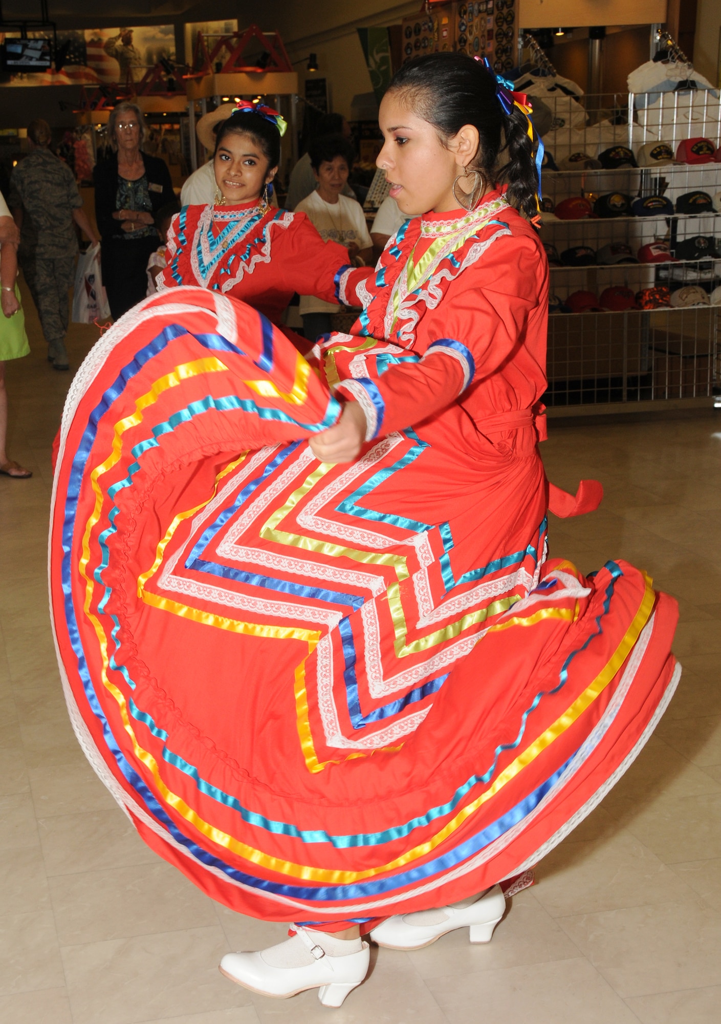 From left, 15-year olds Mariela Albendriz and Erica Plascencia perform a traditional Mexican dance with Vicentenario de Mexico group from Gautier at Saturday’s Hispanic Heritage Month celebration at the main exchange at Keesler Air Force Base, Miss.  Their parents are Estela and Jose Albendriz and Elizabeth and Angel Plascencia.  (U.S. Air Force photo by Kemberly Groue)