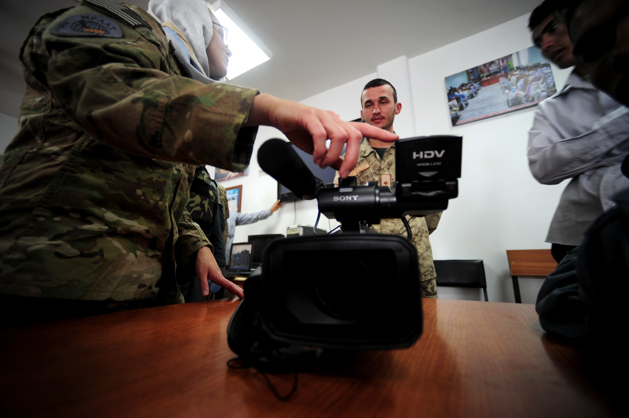 Staff Sgt. Felicia Welch critiques videos shot by Afghanistan National Police, NCO, Nazir Ahmed, Sept. 28, 2011, at the 606th Police Headquarters, Afghanistan.  The goal of the MPAATs is to help Afghanistan security forces public affairs personnel become more productive communicators so they can tell the story of the successes of the ANSF. Welch is part of the MPAAT at Camp Stone, Afghanistan and is deployed from Eglin AFB, Fl., where she is attached to the 40th Weapons Testing Squadron. (U.S. Air Force photo/ Senior Airman Tyler Placie)