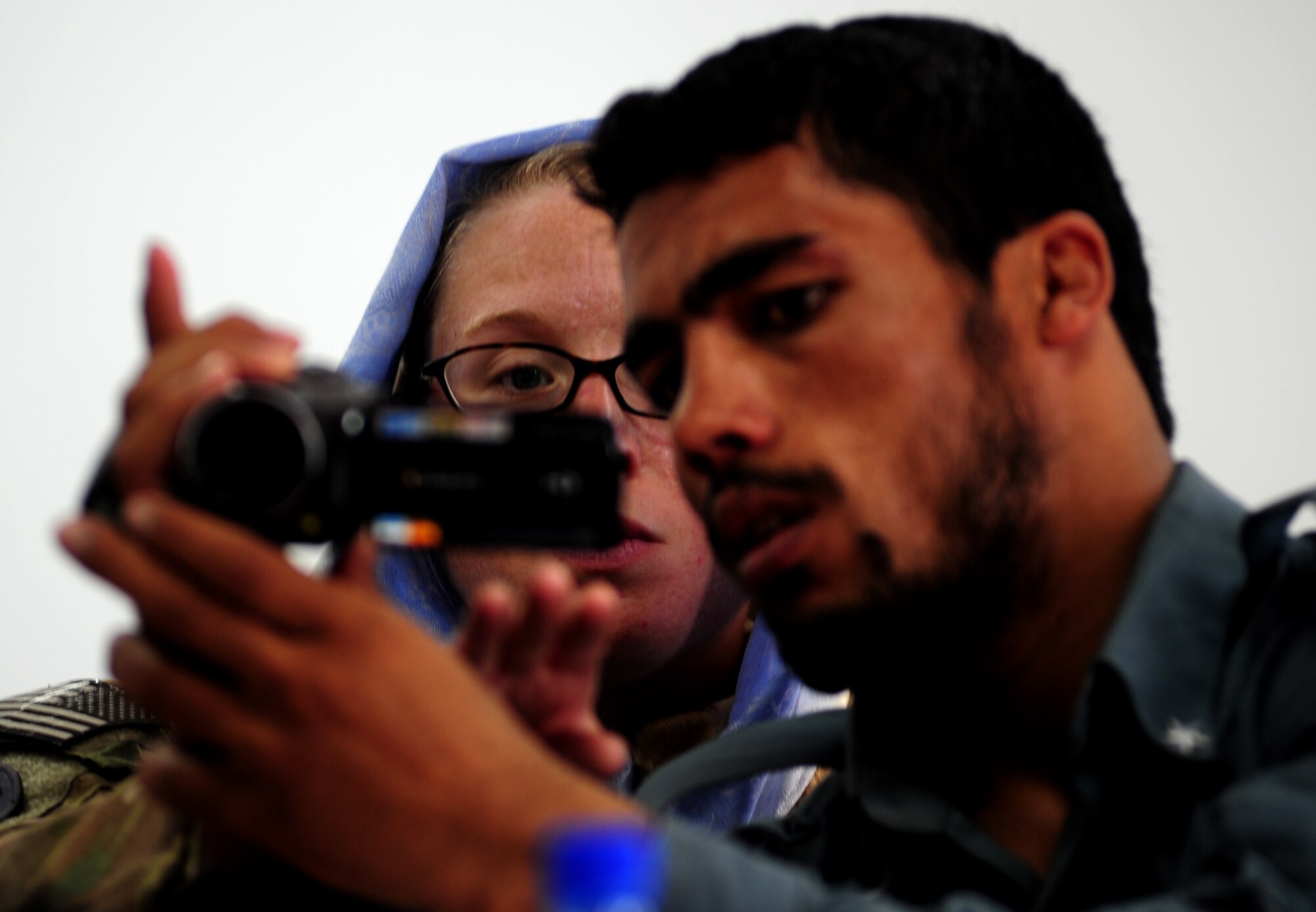 Staff Sgt. Felicia Welch trains Afghanistan National Police NCO Nazir Ahmed about the different angles used when shooting video, Sept. 28, 2011, at the 606th Police Headquarters in Herat, Afghanistan.  The goal of the MPAATs is to help Afghanistan security forces public affairs personnel become more productive communicators so they can tell the story of the successes of the ANSF. Welch is part of the MPAAT at Camp Stone, Afghanistan and is deployed from Eglin AFB, Fl., where she is attached to the 40th Weapons Testing Squadron. (U.S. Air Force photo/ Senior Airman Tyler Placie)