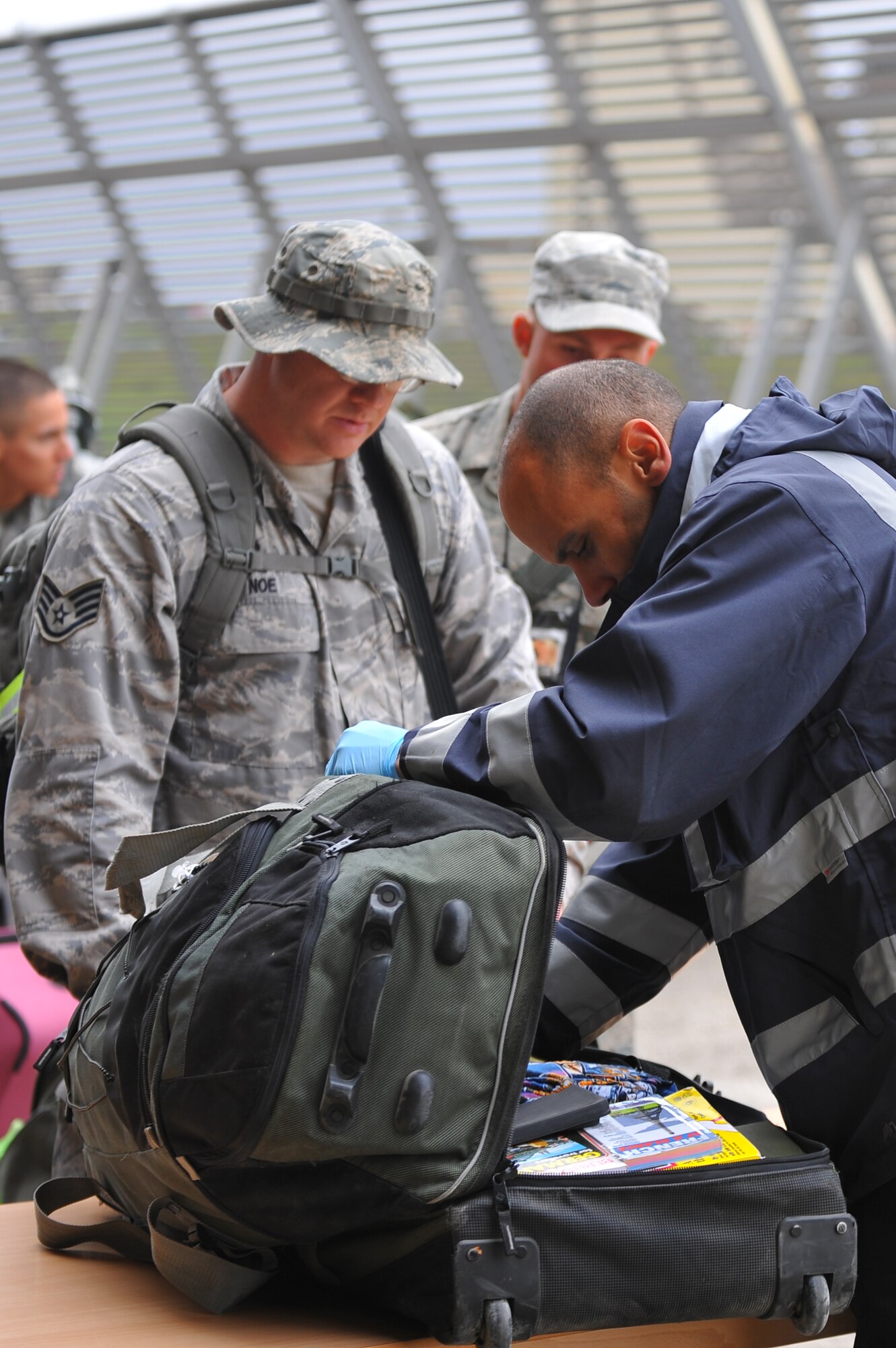 SPANGDAHLEM AIR BASE, Germany – Manuel Globe, right, U.S. Customs agent, searches the bag of Staff Sgt. Jeffrey Noe, United States Air Forces in Europe aircraft maintainer, during a deployment return function here Oct. 11. The returning Airmen were a part of the maintenance support for the 480th Fighter Squadron while they while deployed in support of Operation New Dawn. (U.S. Air Force photo/Airman 1st Class Dillon Davis)
