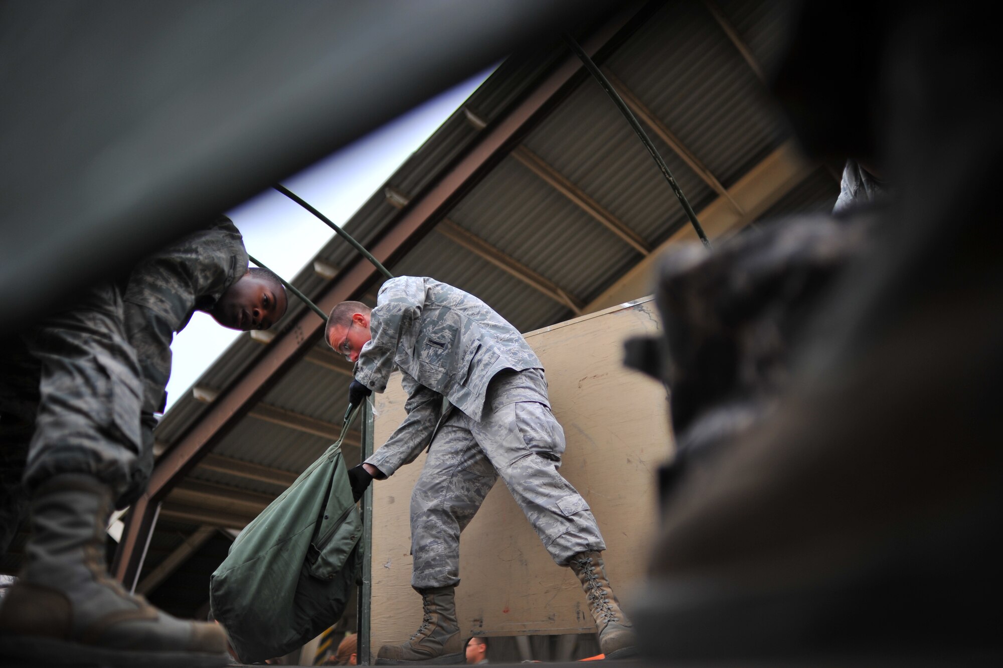 SPANGDAHLEM AIR BASE, Germany – Airman 1st Class Marvin Tookes, left, 52nd Aircraft Maintenance Squadron, and Airman 1st Class Andrew Hoffman, 606th Air Control Squadron, unload luggage from a truck during a deployment return function here Oct. 11. The returning Airmen were a part of the maintenance support for the 480th Fighter Squadron while they while deployed in support of Operation New Dawn. (U.S. Air Force photo/Airman 1st Class Dillon Davis)