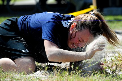 Senior Airman Amy Lexon from the Navy blue team finishes the low crawl during the team relay race at the Festival of Fitness Oct. 7, at Joint Base Charleston. Seventeen, six-man teams competed in the Festival of Fitness which included a 5k run, tug-of-war, trivia questions and a team fitness relay. The 628th Civil Engineer Squadron Lime Green Team was named the overall winner. Lexon is a Phoenix Raven with the 628th Security Forces Squadron.  (U.S. Air Force photo/ Staff Sgt. Nicole Mickle)      