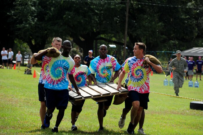 The 628th Communication Squadron's team finish the team fitness relay by running with a pallet and sand-bags during the Festival of Fitness Oct. 7, at Joint Base Charleston. Seventeen, six-man teams competed in the Festival of Fitness which included a 5k run, tug-of-war, trivia questions and a team fitness relay. The 628th Civil Engineer Squadron Lime Green Team was named the overall winner.    (U.S. Air Force photo/Airman 1st Class Ashlee Galloway)
