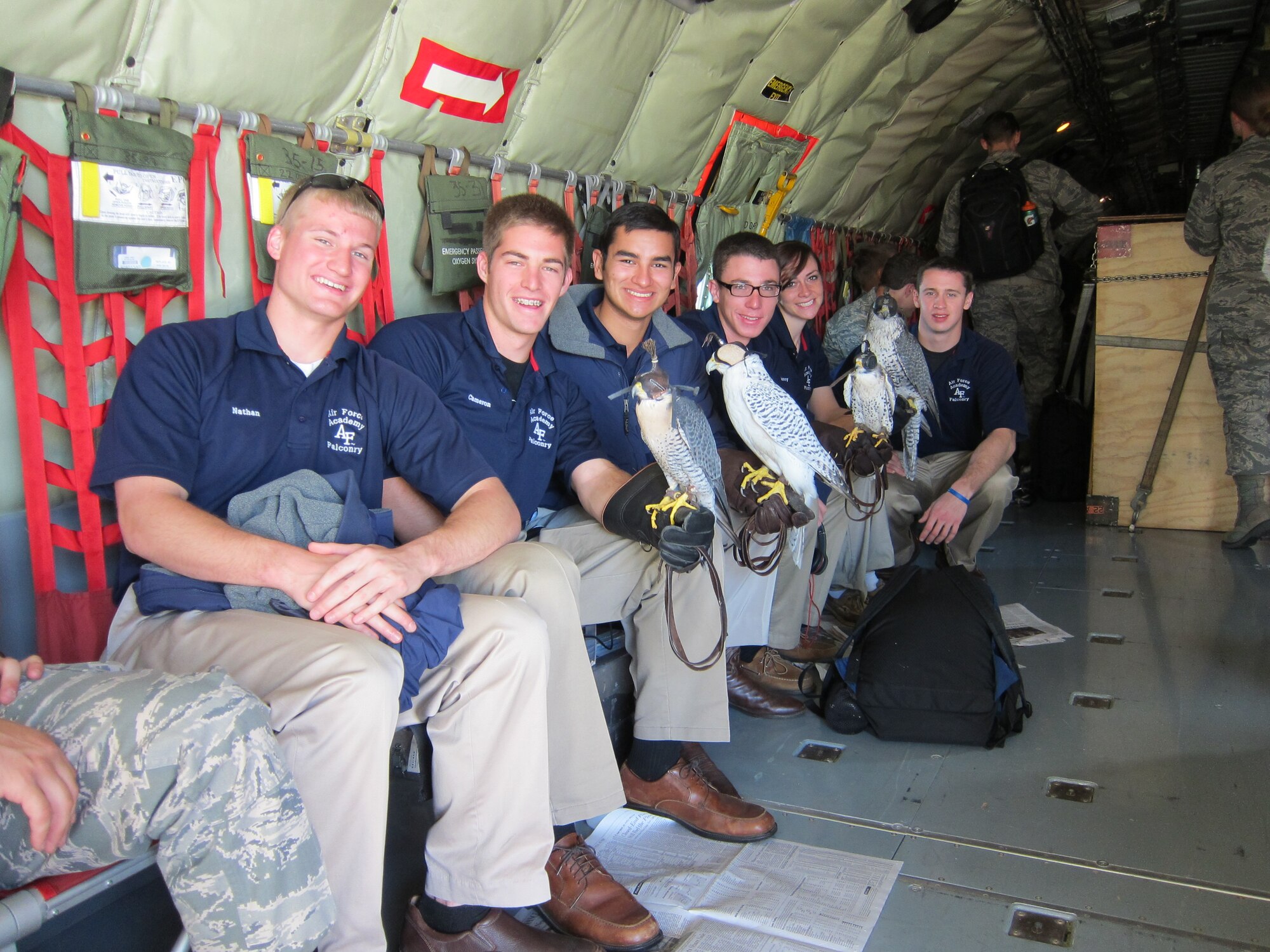 (Left to Right) Air Force Academy Cadets Nathan Lebens, Cameron Harris, Ernesto Guerrero, Trent Grabowski, Jennifer Flynn and 2nd Lt. Ryan Wichman, Officer in Charge of the Air Force Academy Falconry team pose for a photograph with their birds aboard a KC-135 Stratotanker, Oct. 7. Airmen from the 931st Air Refueling Group and the 22nd Air Refueling Wing flew Air Force Academy athletes to South Bend, Indiana to compete against Notre Dame.  (Photo by Lt. Col. Tsuyoshi Tung)