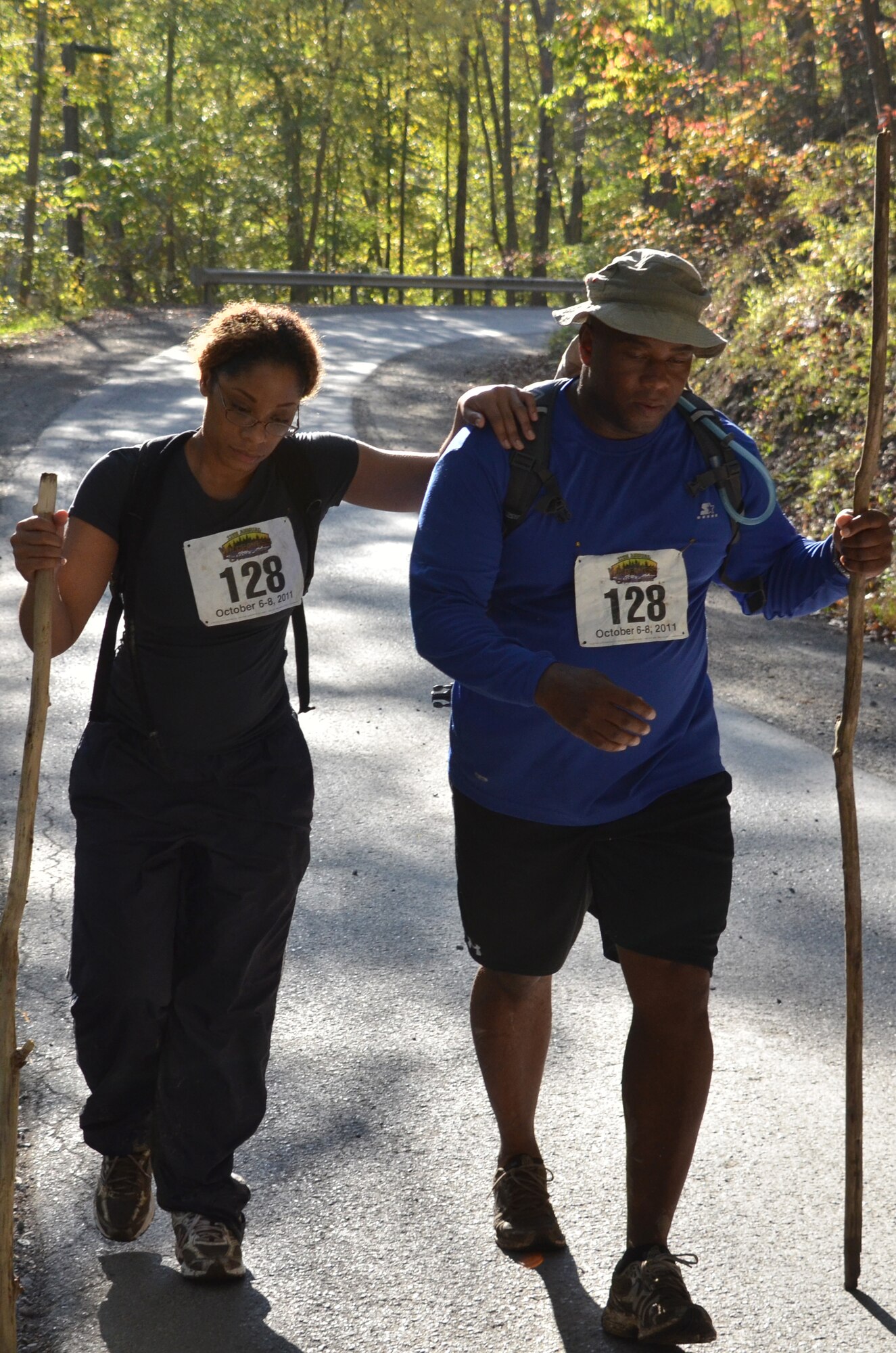 U.S. Navy Petty Officer 1st Class Angela Lewis and U.S. Army Lt. Col. James Wilkinson, D Smurfs team, support each other during the last quarter mile of the 11th Annual Wilderness Challenge, Oct. 8, 2011, in Fayetteville W. Va. The last part of the two day challenge was a 15-mile hike through muddy mountain paths. (U.S. Air Force photo by Tech. Sgt April Wickes/Released)

