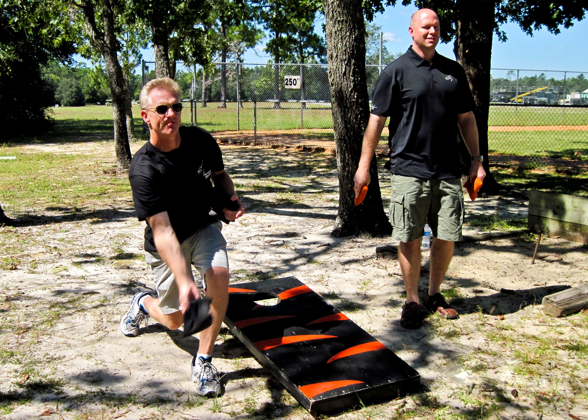 Cmdr. Scott Kartvedt, commander of Naval F-35 squadron VFA-101, tosses a bean bag as Cmdr. John Allison, also from VFA-101, waits to throw, Oct. 7 at Eglin Air Force Base, Fla.  The 33rd Fighter Wing Airmen, Marines and Sailors took some time off from F-35 preparations to come together for some Wingman Day activities. (U.S. Air Force photo/Maj. Karen Roganov)