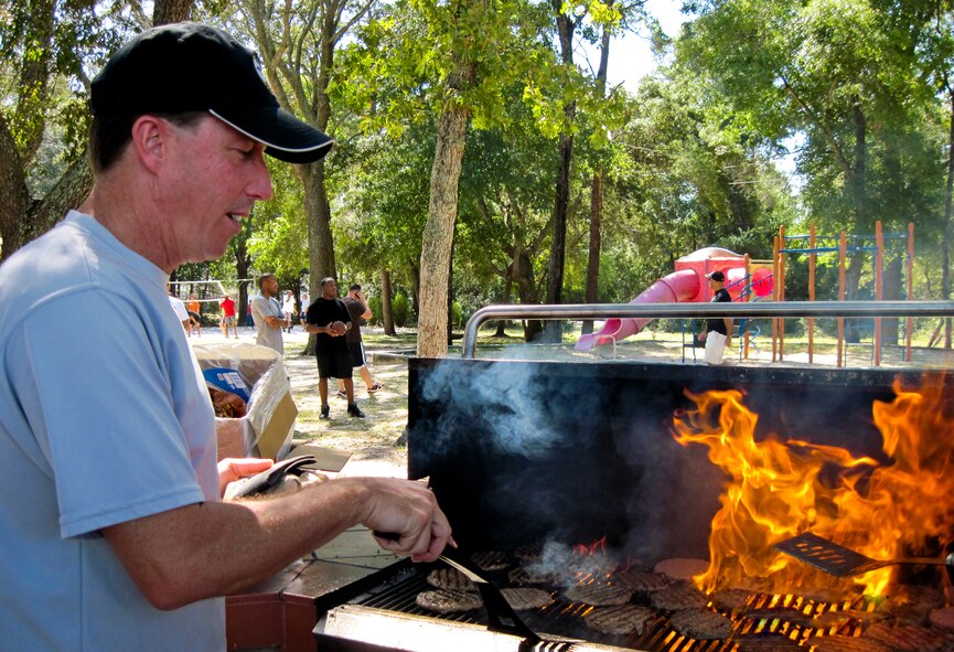 Chief Master Sgt. Rodney T. Cherry, of the 33rd Maintenance Group, prepares burgers for about 400 members of the 33d Fighter Wing. Eight of the wing’s chiefs kept the charred burgers cooking and the plates full for the lunch portion of Wingman Day Oct. 7. (U.S. Air Force photo/Maj. Karen Roganov)