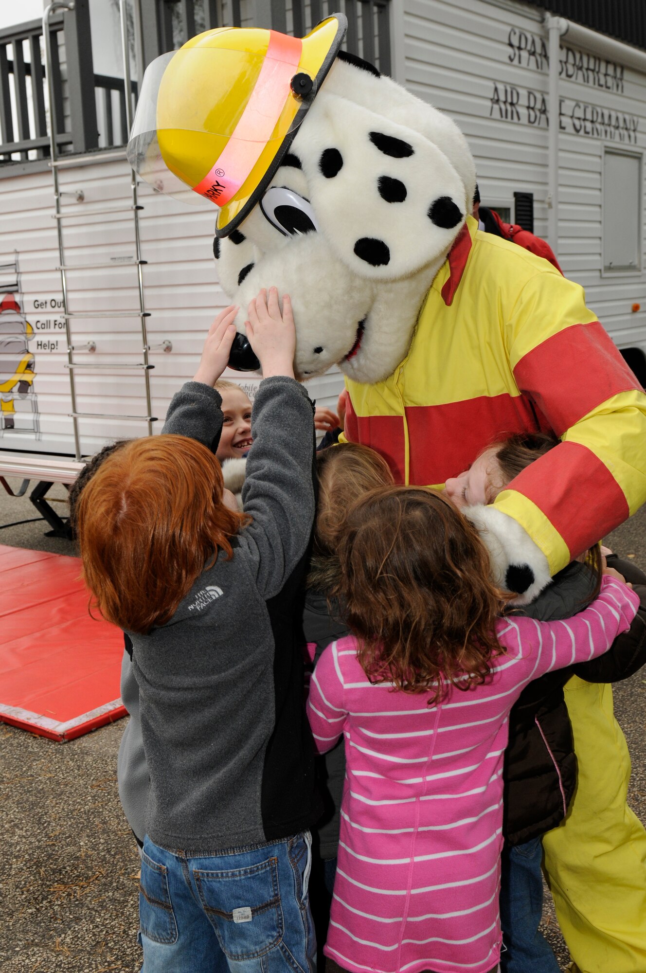 SPANGDAHLEM AIR BASE, Germany -- Sparky the Fire Dog hugs children from the Spangdahlem Elementary School during a fire safety demonstration here Oct. 12. National Fire Prevention Week is a week-long schedule of events that promotes fire safety and prevention through demos, visits from Sparky the Fire Dog and a parade in Spangdahlem housing. (U.S. Air Force photo/Airman 1st Class Brittney Frees)
