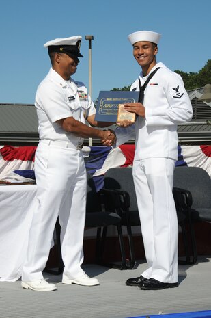 Petty Officer 3rd Class Yuji Williams receives the enlisted Honor Man plaque from Master Chief Petty Officer Gamal Coles during the Naval Nuclear Power Training Command graduation ceremony for class 1104 at Joint Base Charleston - Weapons Station, Oct. 7. The plaque is awarded to the Sailor with the highest grade point average for the enlisted class. Williams, a Machinist's Mate, earned an overall GPA of 3.93. Gamal is the NNPTC command master chief. (U.S. Navy photo/Petty Officer 3rd Class Brannon Deugan)