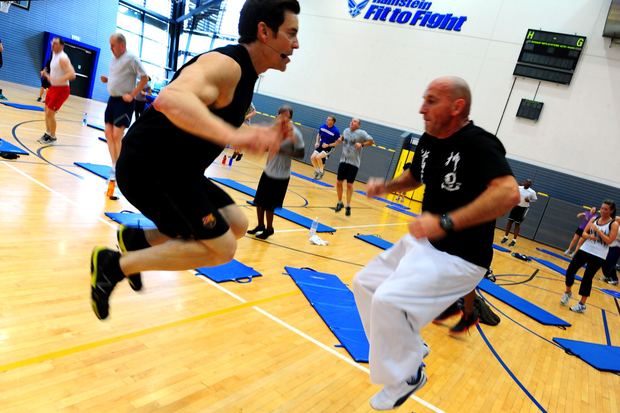 Tony Horton, creator of workout program P90X, motivates Paul Wagner, 886th Civil Engineer Squadron fire inspector, during a calisthenics routine at the southside gym, Ramstein Air Base, Germany, Oct. 7, 2011. Horton conducted two free strength training workout sessions for 325 military personnel and dependents. (U.S. Air Force photo by Airman 1st Class Brea Miller)