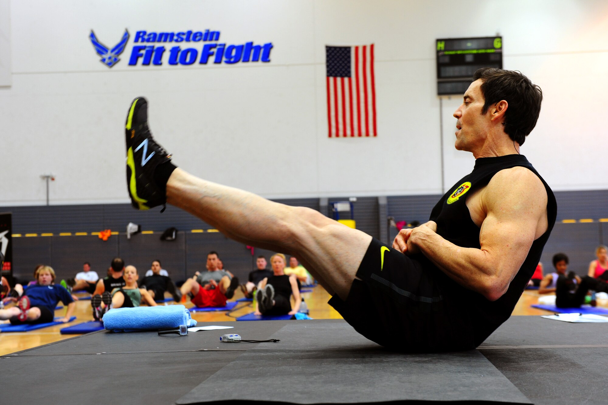 Tony Horton, creator of workout program P90X, leads an abdominal excercise during a calisthenics routine at the southside gym, Ramstein Air Base, Germany, Oct. 7, 2011. Horton conducted two free strength training workout sessions for 325 military personnel and dependents. (U.S. Air Force photo by Airman 1st Class Brea Miller)