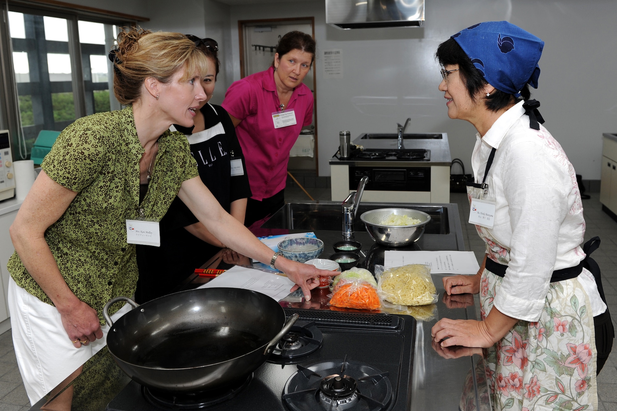 Kati Molloy, Akiko Pollock, Kathy Jimenez and Hiroko Murayama participate in a cultural exchange cooking class with members of the local community at the Kadena Town Rotary Plaza Oct. 5. Those who attended the class learned to cook Yakisoba, Mabo Tofu and rice balls with salmon flakes during the cultural exchange. The American women are from Kadena Air Base and the Okinawan women are from the Kadena Chamber of Commerce Women’s Division. (U.S. Air Force photo/Junko Kinjo)