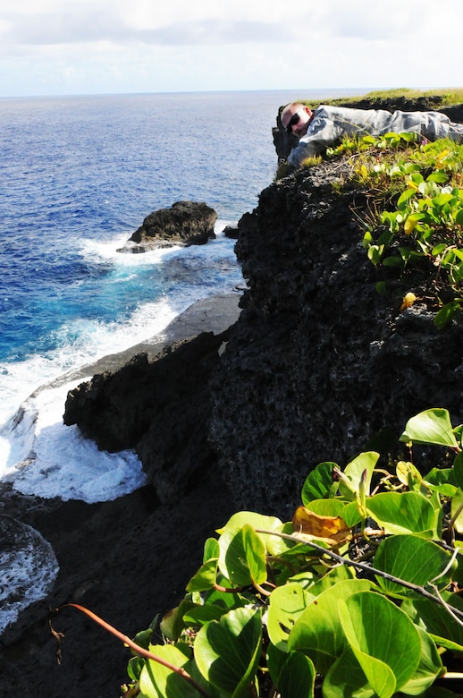 ANDERSEN AIR FORCE BASE, Guam – Maj. Robert Leo, 36th Maintenance Squadron commander, lays near the edge of a memorial overlook during a staff visit and historical tour of Tinian Island Oct. 11. The island has multiple historical sites throughout the jungle honoring the heritage of the island. (U.S. Air Force photo/ Senior Airman Carlin Leslie)