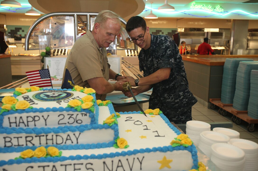 The oldest sailor aboard Marine Corps Air Station Cherry Point, Command Master Chief Glenn A. Baxter, cuts the cake with the youngest sailor in the Naval Health Clinic, Seaman Frankie J. Trabbie, cut the Navy's birthday cake together at the chow hall, Oct. 13. ::r::::n::::r::::n::"It's pretty cool, it's an honor to cut the cake with the oldest enlisted, Master Chief Baxter," said Trabbie. "The oldest and youngest enlisted cutting and eating the cake together symbolizes the passing on of experience. He has a lot of knowledge."::r::::n::::r::::n::"We cherish our heritage," said Baxter. "The Navy has done a lot of great things over the years and we continue to do great things. We look forward to working with our sister services in preserving democracy and freedom around the world just like the last 236 years."
