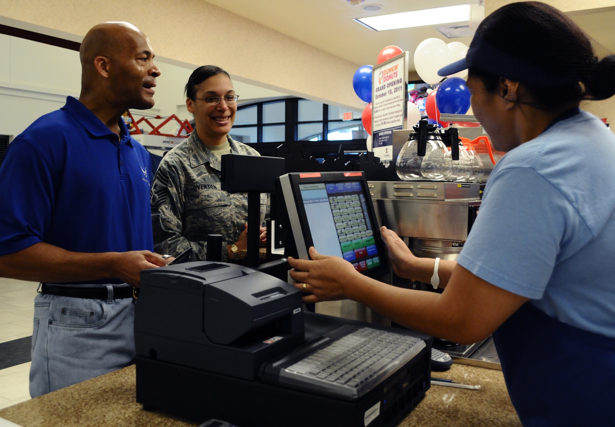 ANDERSEN AIR FORCE BASE, Guam—Chief Master Sgt. Margarita Overton, 36th Wing command chief, orders coffee with her husband, Mark during the grand opening of the Duncan Donuts coffee shop here, Oct. 14. The Army and Air Force Exchange Service (AAFES) put in the new store to improve the quality of life for Airmen at Andersen. (U.S. Air Force photo by Senior Airman Benjamin Wiseman/Released)