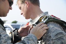 Tech. Sgt. Jason Martinez, an Air Force survival, evasion, resistance and escape specialist from the 8th Operations Support Squadron, and their NCO in charge of weapons, tactics and personnel recovery, makes sure an Army member from the Special Operations Command Korea's 39th Special Forces Detachment has his parachute ready to go before boarding a C-130H Hercules from Yokota Air Base, Japan, at Kunsan Air Base, Republic of Korea, Oct. 8, 2011. The U.S. Air Force and SOCKOR were performing a jump together at 10,000 feet from a C-130, highlighting military free-fall operations during the Gunsan-Saemangeum Airshow in Gunsan City. (U.S. Air Force photo by Staff Sgt. Rasheen A. Douglas/Released)