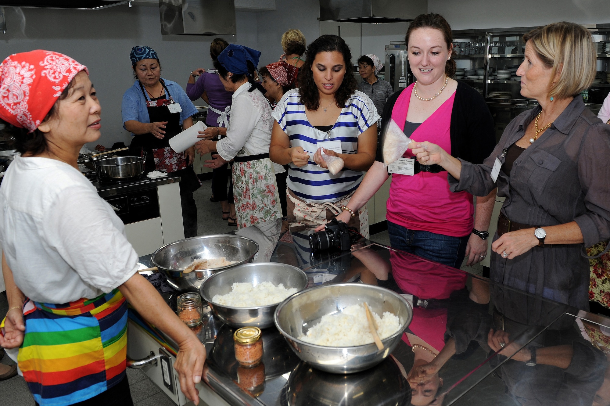 Fusae Arakaki, U.S. Air Force 1st Lt. Natassia Cherne, U.S. Air Force 2nd Lt. Hope Cronin and Kim Nahom participate in a cultural exchange cooking class with members of the local community at the Kadena Town Rotary Plaza Oct. 5. The class was hosted by the Kadena Chamber of Commerce Women’s Division and the 18th Wing Public Affairs community relations office and was a cultural exchange between the local community and members of Kadena Air Base.  (U.S. Air Force photo/Junko Kinjo)