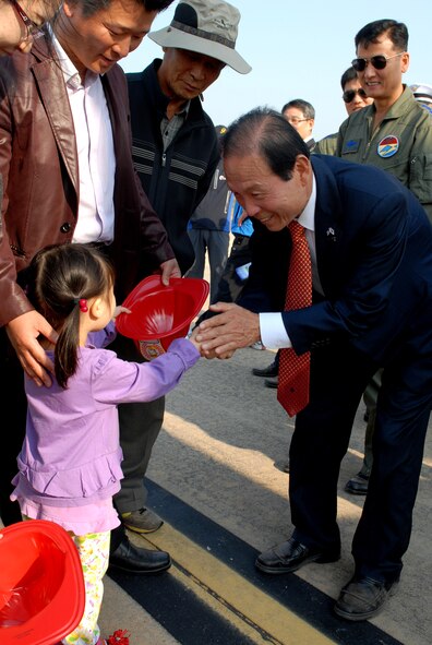 A little Korean girl is greeted by the Gunsan City mayor during the 2011 Gunsan-Saemangeum Air Show at Kunsan Air Base, Republic of Korea, Oct. 8, 2011. The air show featured many static displays and performances from across the Pacific Air Forces and Korean peninsula. (U.S. Air Force photo by Senior Airman Benjamin Stratton/Released)