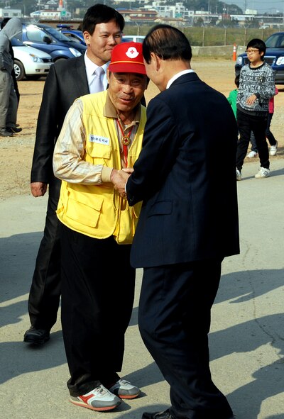 An elderly Korean man is greeted by the Gunsan City mayor during the 2011 Gunsan-Saemangeum Air Show at Kunsan Air Base, Republic of Korea, Oct. 8, 2011. The air show featured many static displays and performances from across the Pacific Air Forces and Korean peninsula. (U.S. Air Force photo by Senior Airman Benjamin Stratton/Released)