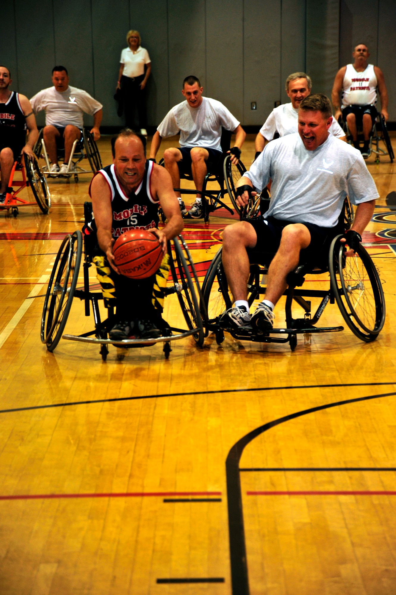 Bryan Lynde, a basketball player for the Mobile Patriots, left, steals the basketball from U.S. Air Force Col. Curt Van De Walle, commander of the 1st Special Operations Mission Support Group, right, during the sixth annual Wheelchair Basketball Exhibition Game at the Aderholt Fitness Center on Hurlburt Field, Fla., Oct. 7, 2011. The event was held to highlight the contributions of handicapped individuals as part of National Disability Employment Awareness Month. (U.S. Air Force photo/Airman 1st Class Christopher Williams)(RELEASED)

