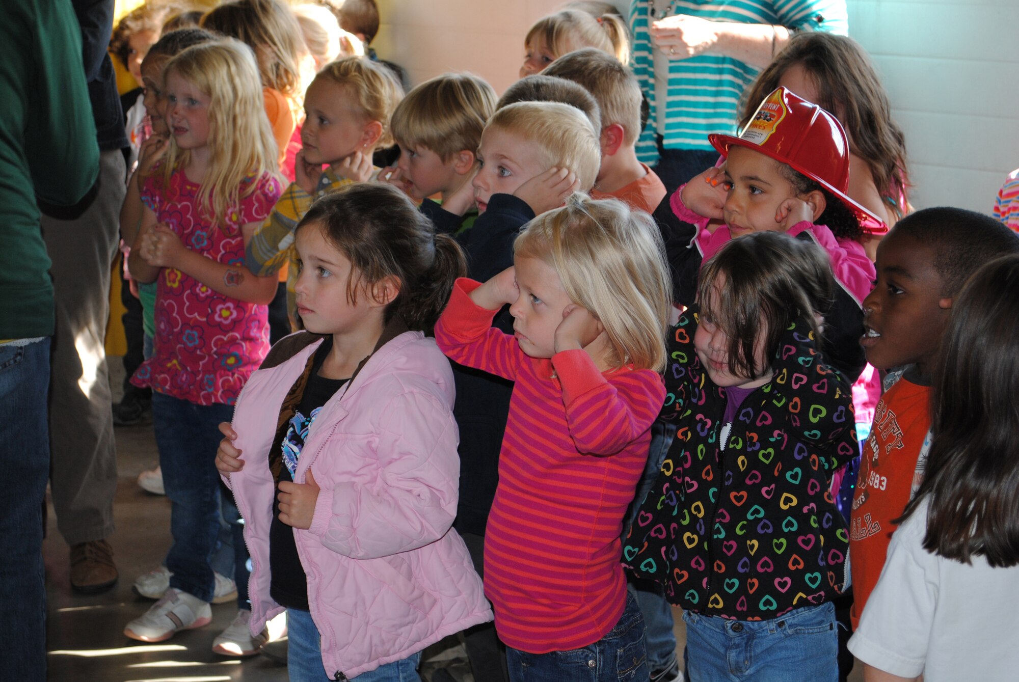 The children cover their ears in anticipation of how loud the sirens on the fire truck would be when a team of firefighters dispatched from the station.  (U.S. Air Force photo/Airman Cortney Paxton)