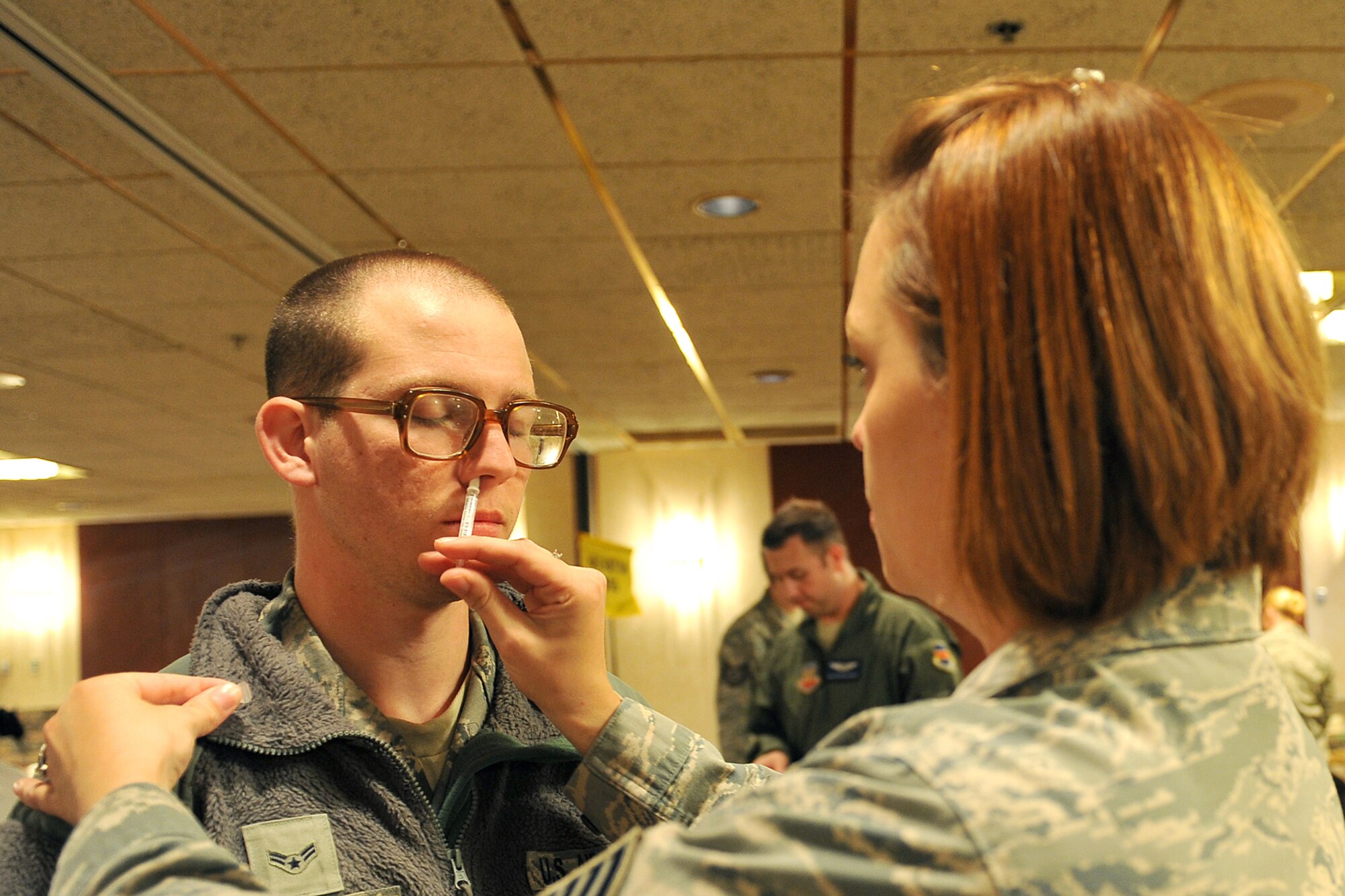 U.S. Air Force Airmen 1st Class Kevin Lee, 55th Security Forces Squadron, receives a influenza mist inoculation from U.S. Air Force Staff Sgt. Christie Schlattweiler, 55th Medical Group, during a point of dispensing exercise Oct. 7 in the Community Activity Center on Offutt Air Force Base, Neb. The exercise tested the 55 MDG's real-world procedure for dispensing medical countermeasures and assessed their ability to respond to a public health emergency. (U.S. Air Force photo by Charles Haymond/Released)
