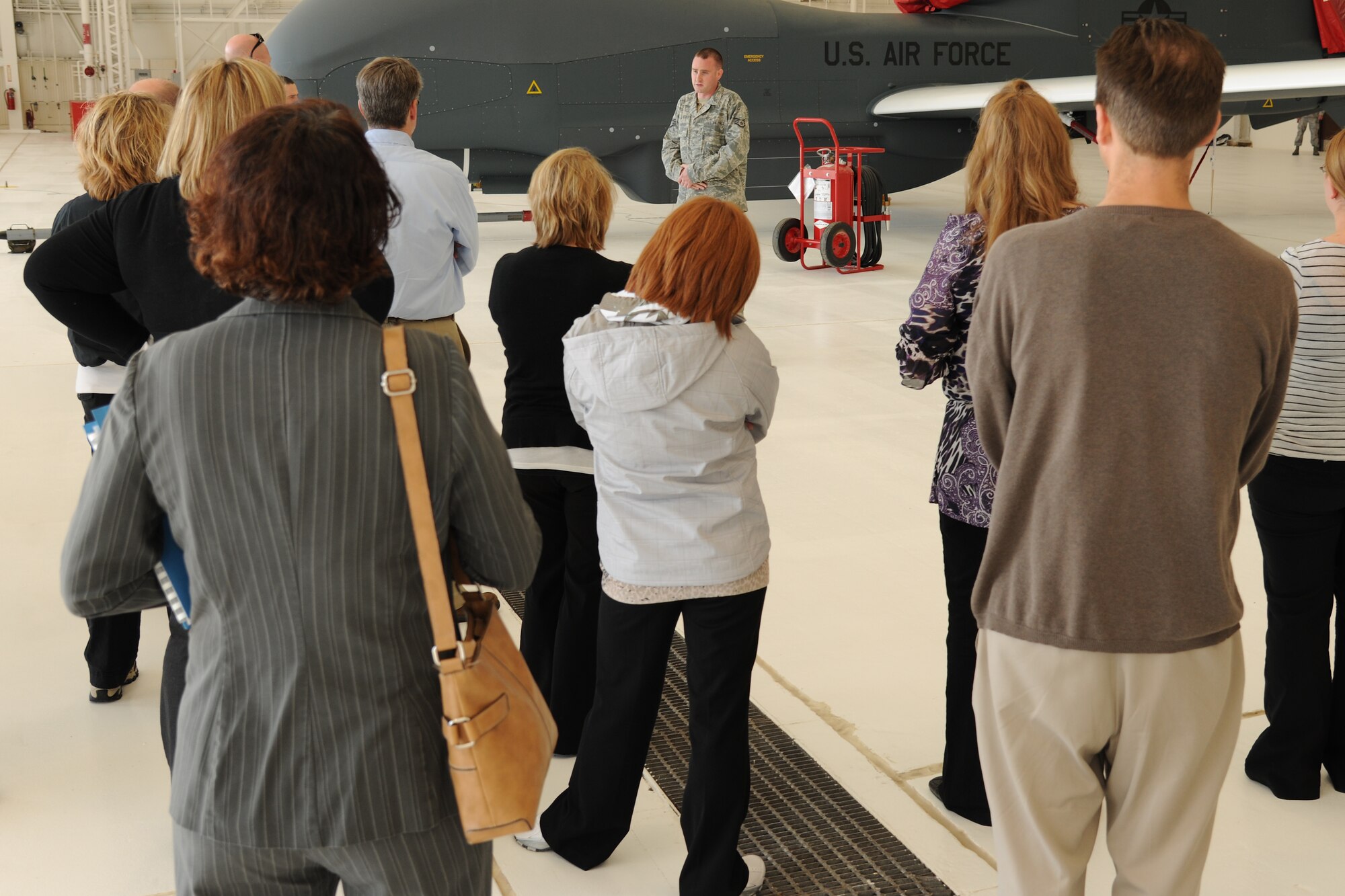 A U.S. Air Force staff sergeant briefs members of the Grand Forks/East Grand Forks Chamber of Commerce about the RQ-4 Global Hawk during a day-long base tour on Oct. 12 on Grand Forks Air Force Base, N.D. The chamber holds the annual training to help develop local leaders and officials say the visit to the base is important to helping civilians in the course understand the importance of the military in the community. (U.S. Air Force photo by Airman 1st Class Ashley N. Taylor)