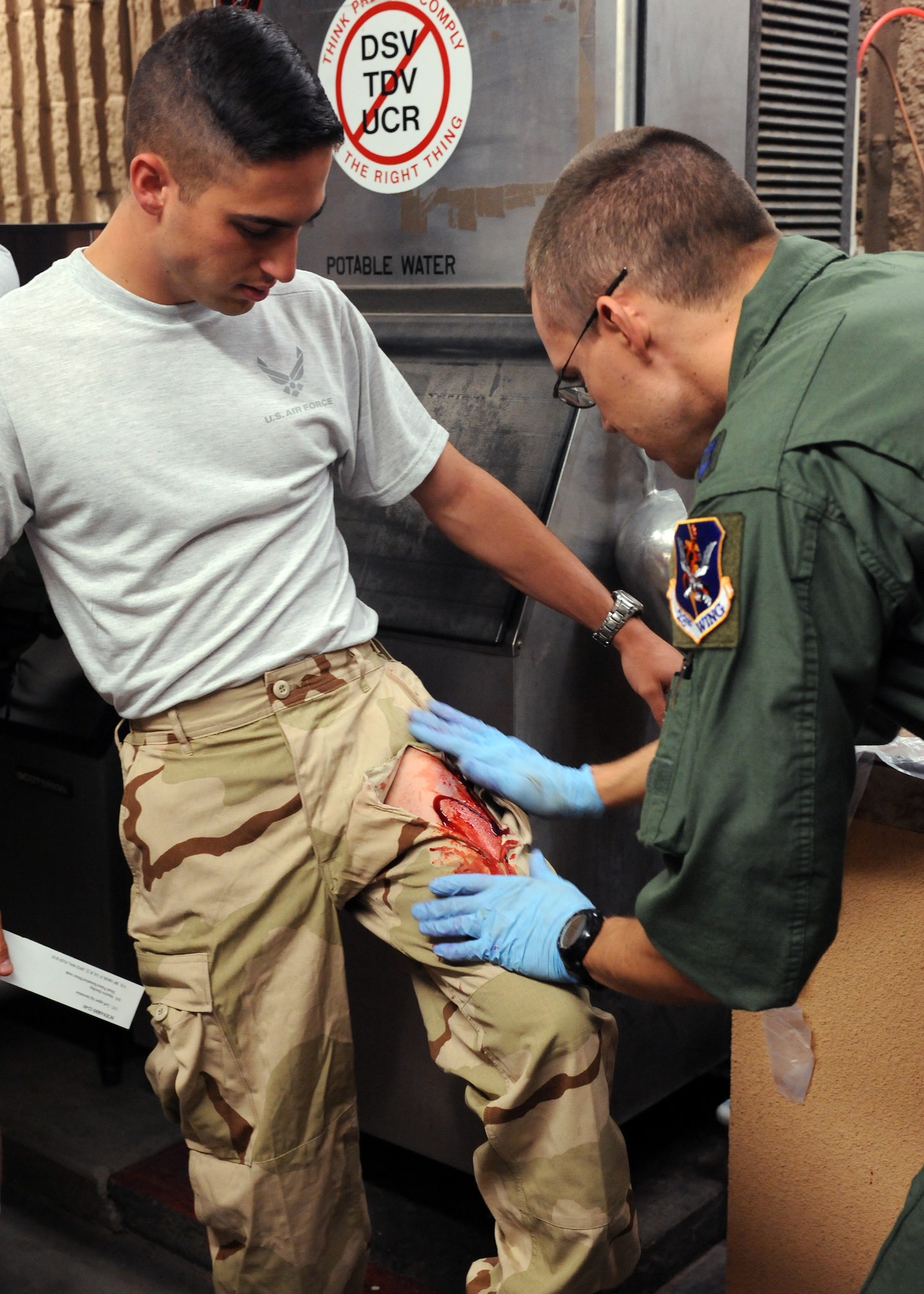 DAVIS-MONTHAN AIR FORCE BASE, Ariz. – Capt. Erik DeSoucy, 563rd Operations Support Squadron flight physician, applies fake blood to the pants of Braden Vincent, University of Arizona Air Force ROTC cadet, to aid in the realism of the Vincent’s simulated injury during the Angel Thunder exercise here Oct. 11. Approximately 1,400 U.S. Military, federal and state employees, and coalition forces are participating in the fifth-annual Angel Thunder exercise, the largest military combat search and rescue exercise in the world. (U.S. Air Force photo/Airman 1st Class Timothy D. Moore)