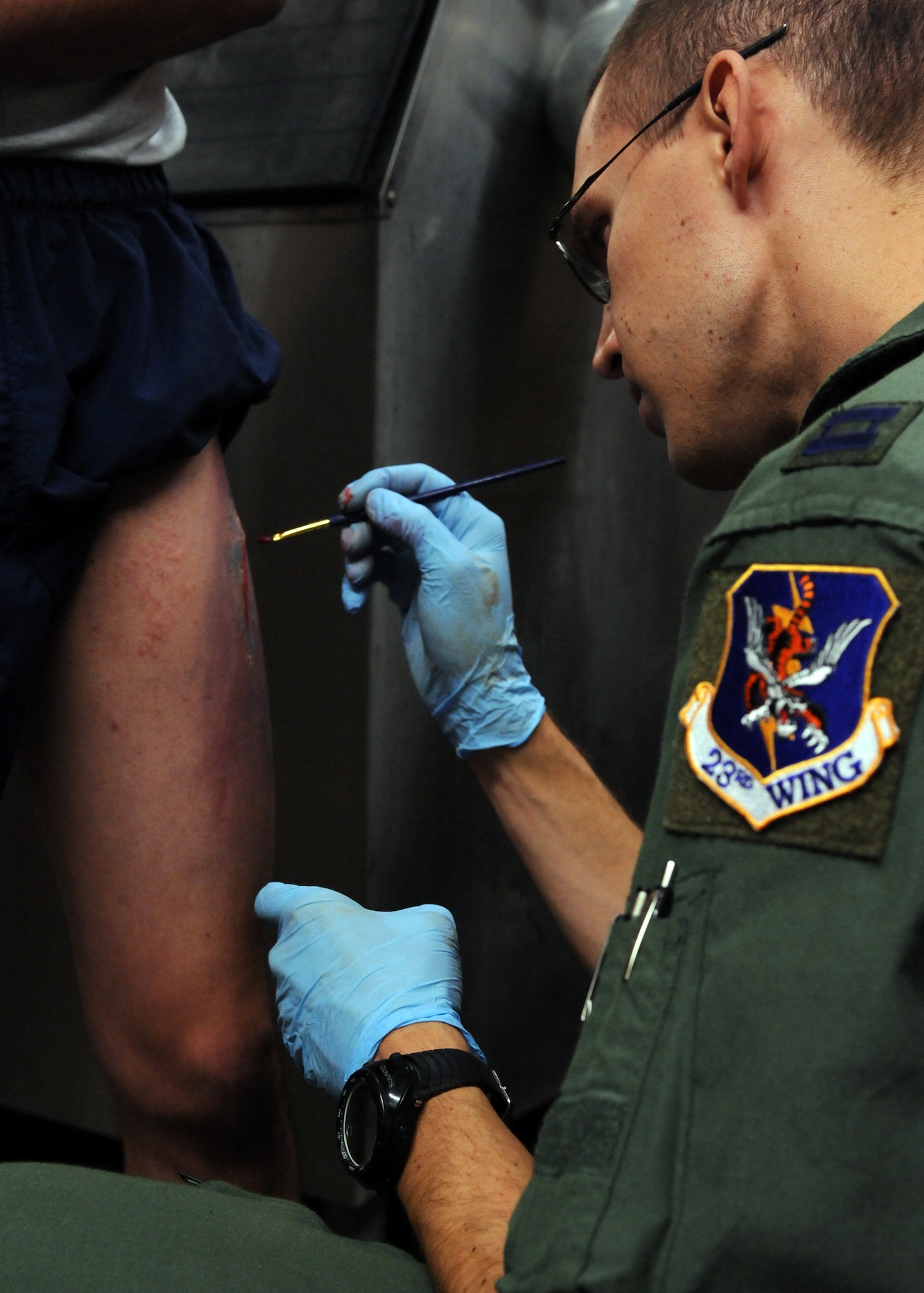 DAVIS-MONTHAN AIR FORCE BASE, Ariz. – Capt. Erik DeSoucy, 563rd Operations Support Squadron flight physician, applies fake blood to a simulated laceration on the leg of Braden Vincent, University of Arizona Air Force ROTC cadet, at his moulage station during the Angel Thunder exercise here Oct. 11. Approximately 1,400 U.S. Military, federal and state employees, and coalition forces are participating in the fifth-annual Angel Thunder exercise, the largest military combat search and rescue exercise in the world. (U.S. Air Force photo/Airman 1st Class Timothy D. Moore)